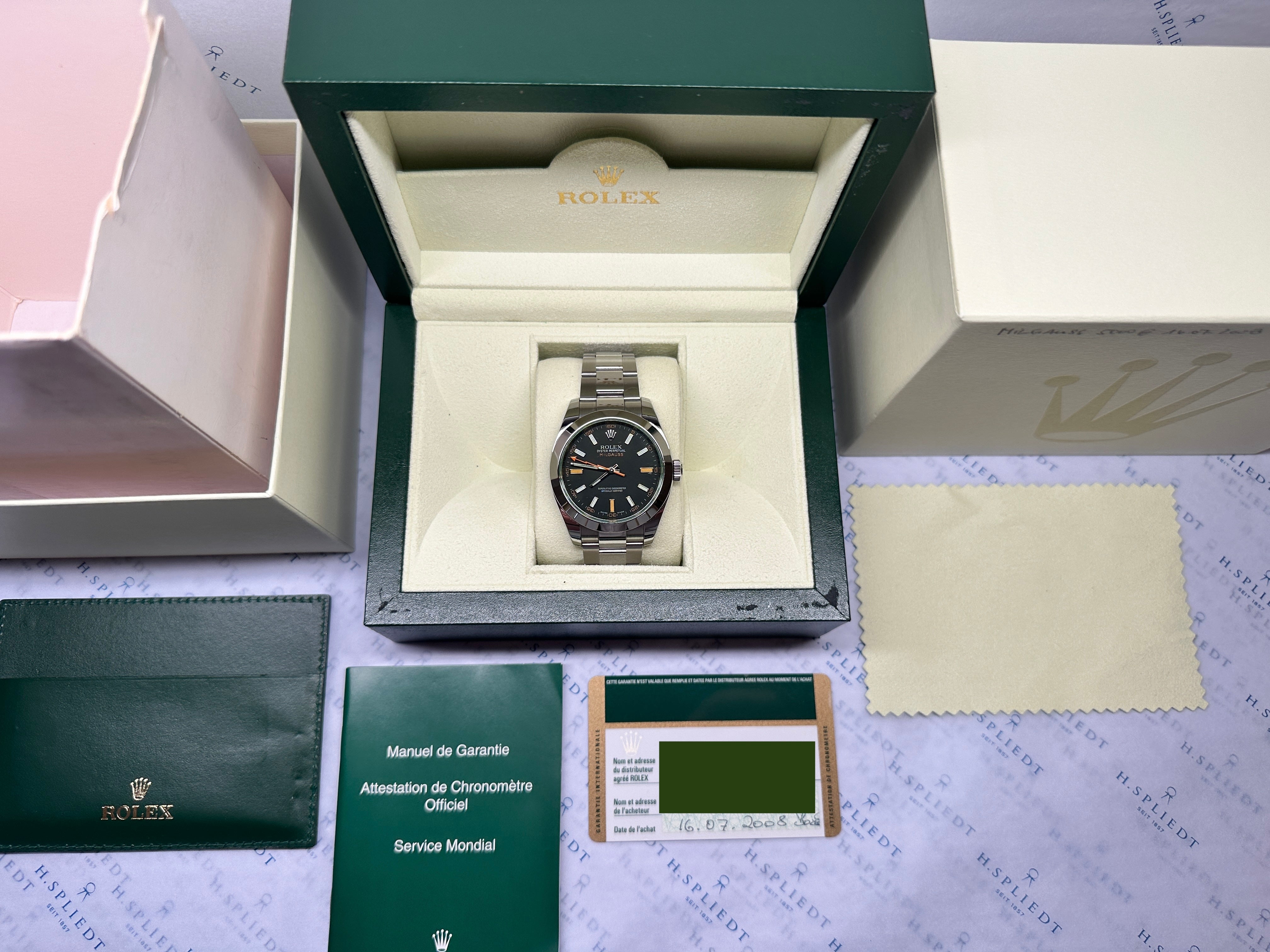 Rolex Milgauss 116400GV in Box mit Papieren auf Unterlage