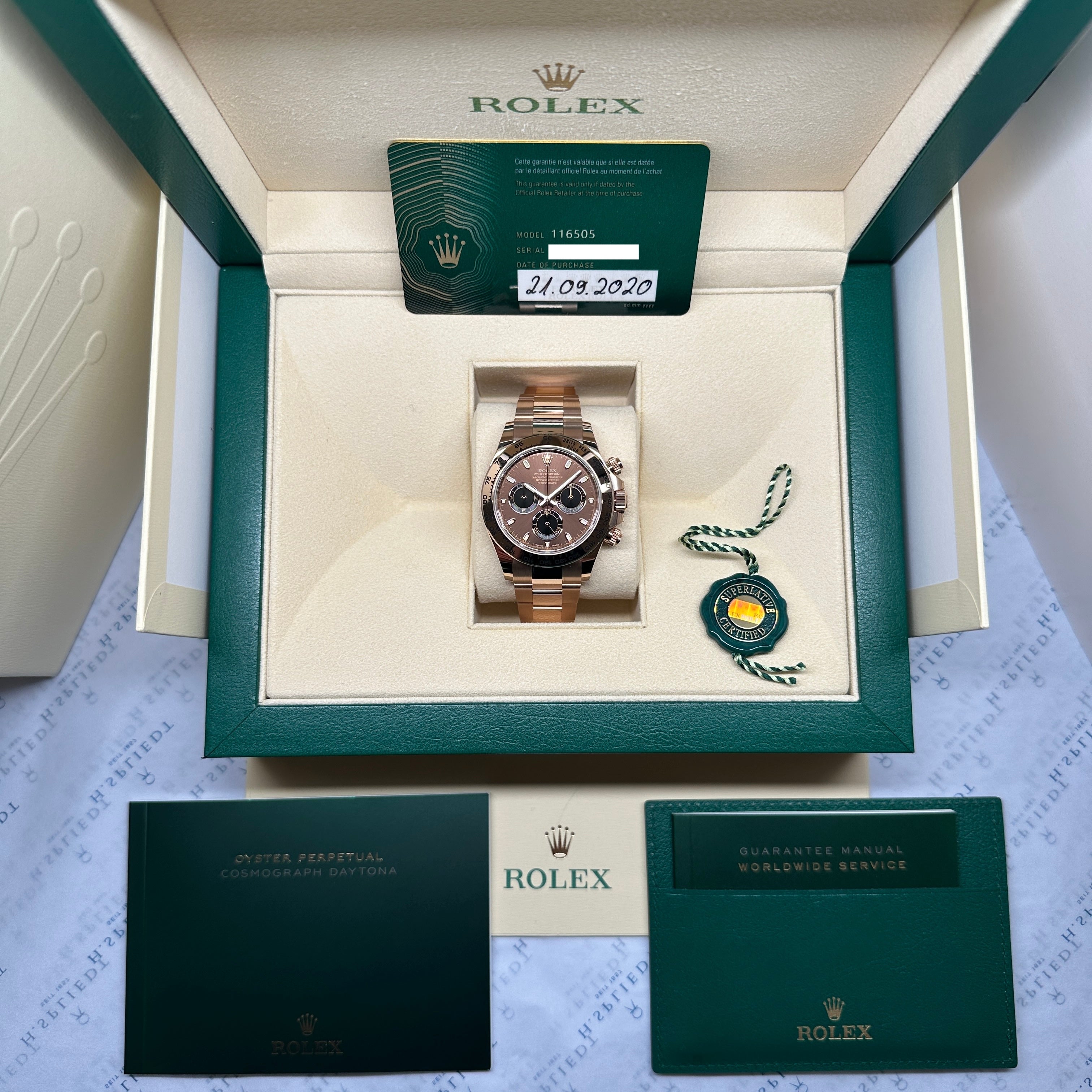 Rolex Daytona Everose mit Schokoladen-Zifferblatt im geöffneten grünen Karton mit Garantiekarte und Broschüre