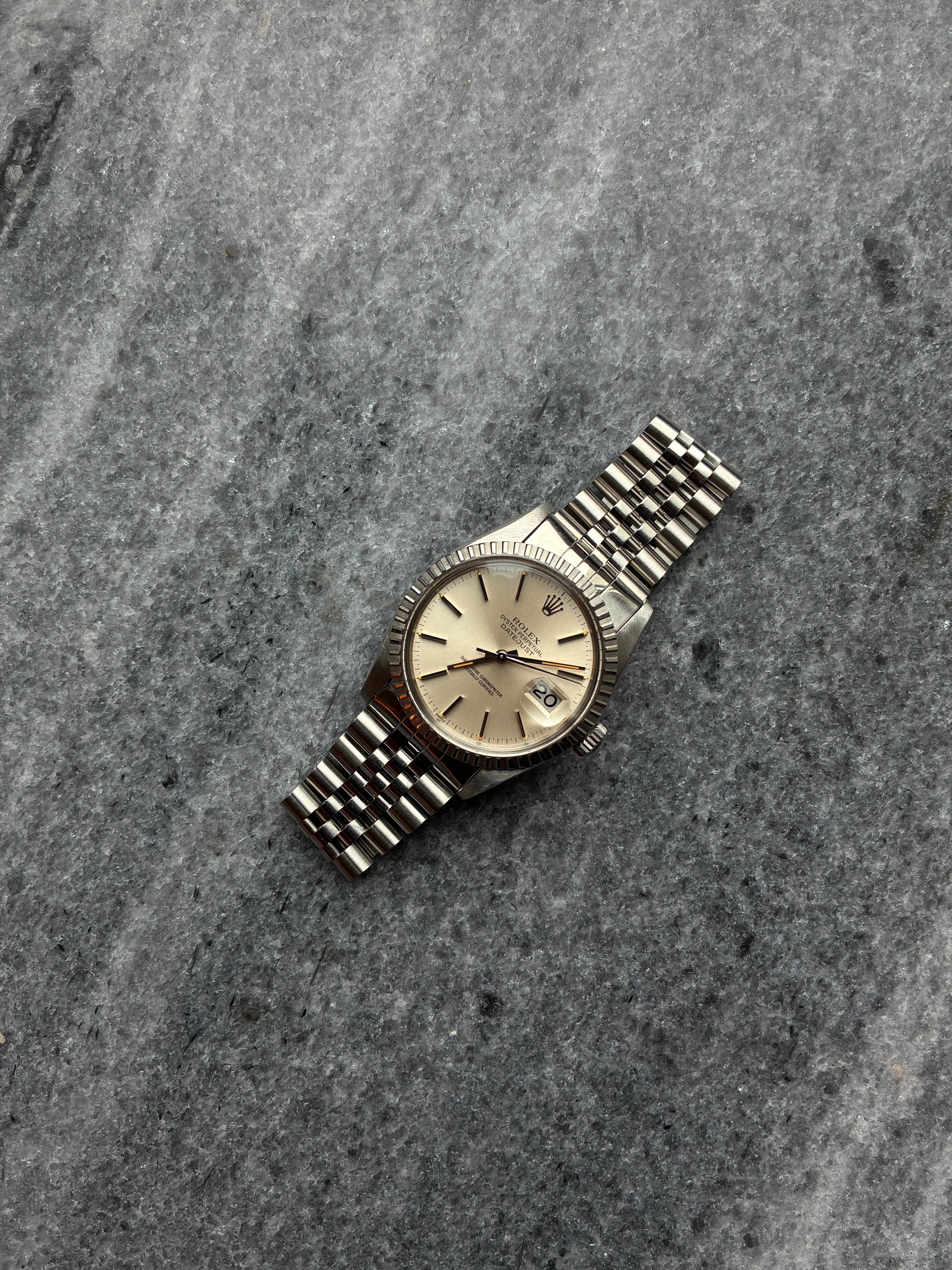 Rolex Datejust 36 mit silbernem Zifferblatt und 10 Indizes, auf grauem Steinuntergrund