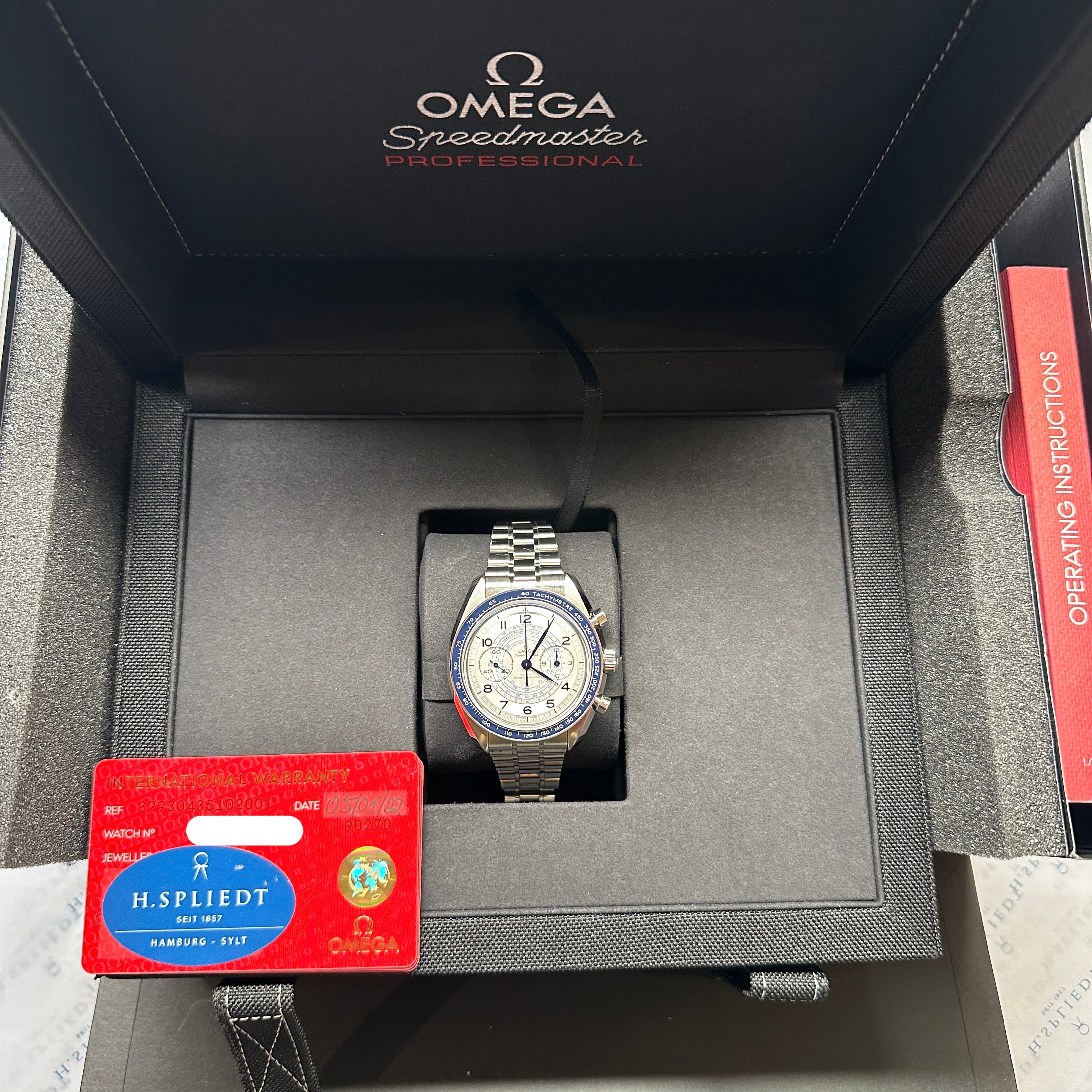 Omega Speedmaster Professional Chronoscope im geöffneten schwarzen Uhrenkasten mit Garantiekarte