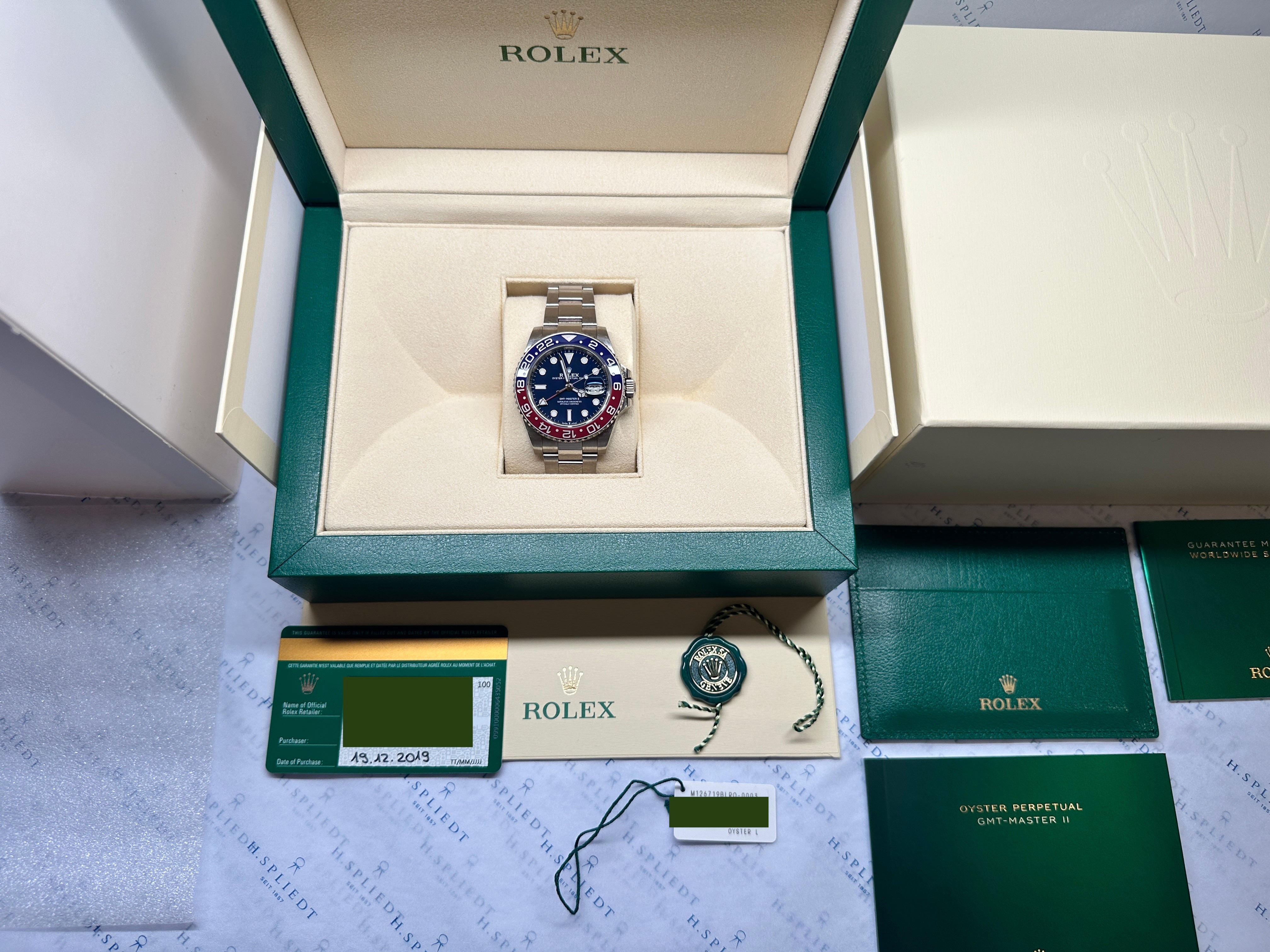 Rolex GMT-Master II im geöffneten grünen Karton mit Zubehör