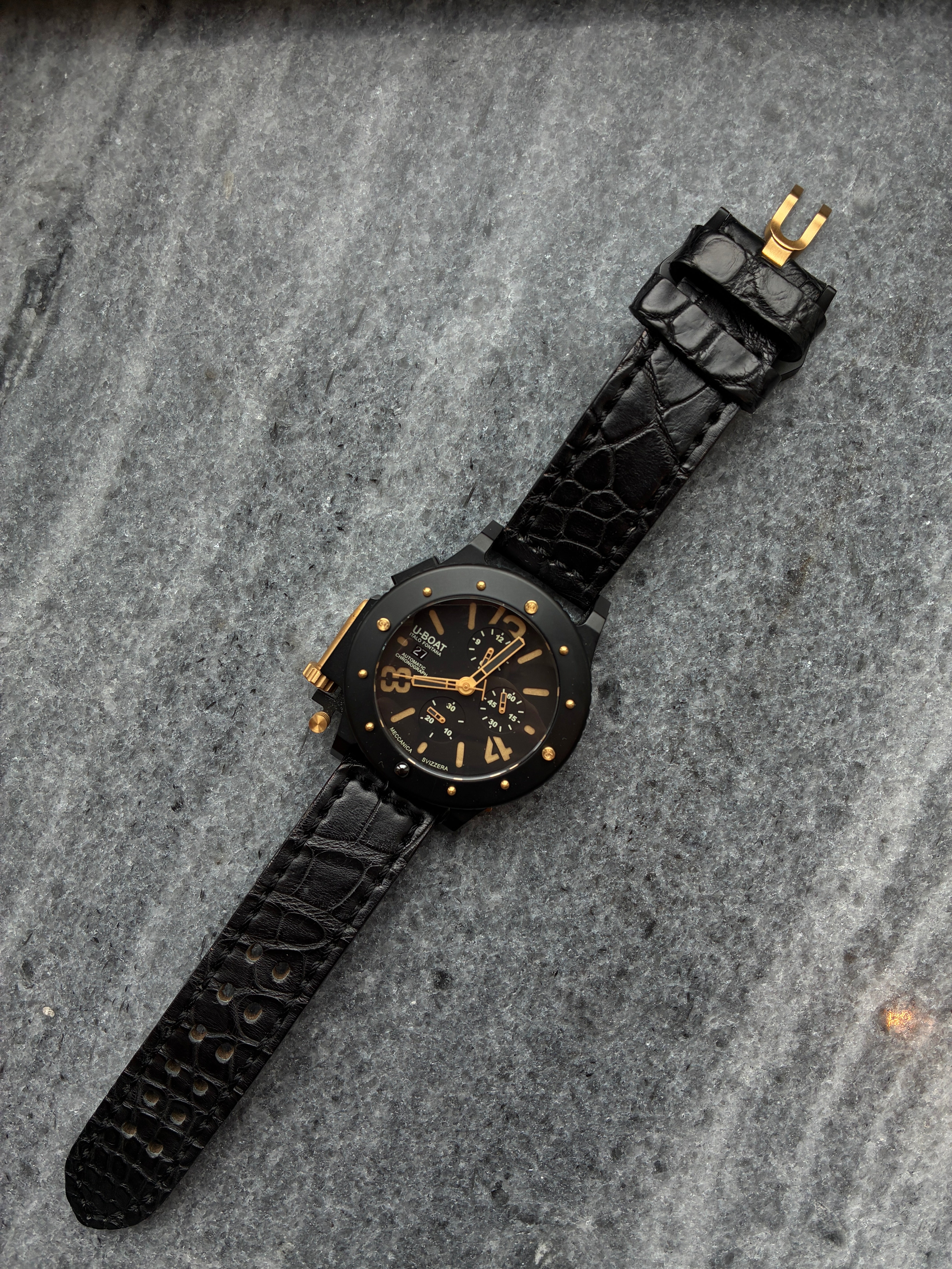 U-Boat U-42 Herrenuhr mit schwarzem Zifferblatt und Lederarmband auf Marmor Hintergrund