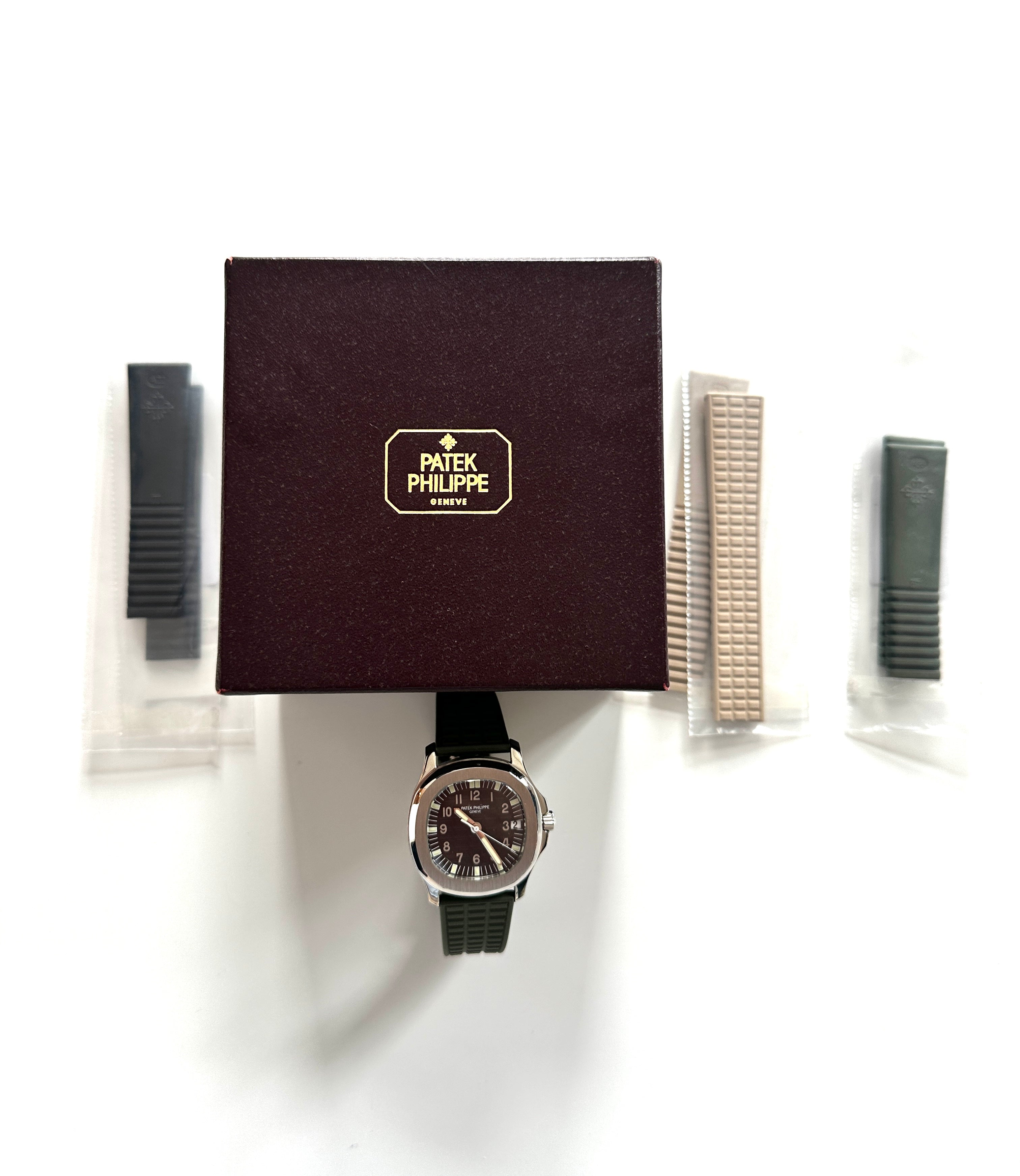 Patek Philippe Aquanaut 38mm Edelstahl mit schwarzem Kautschukband und Box auf weissem Hintergrund