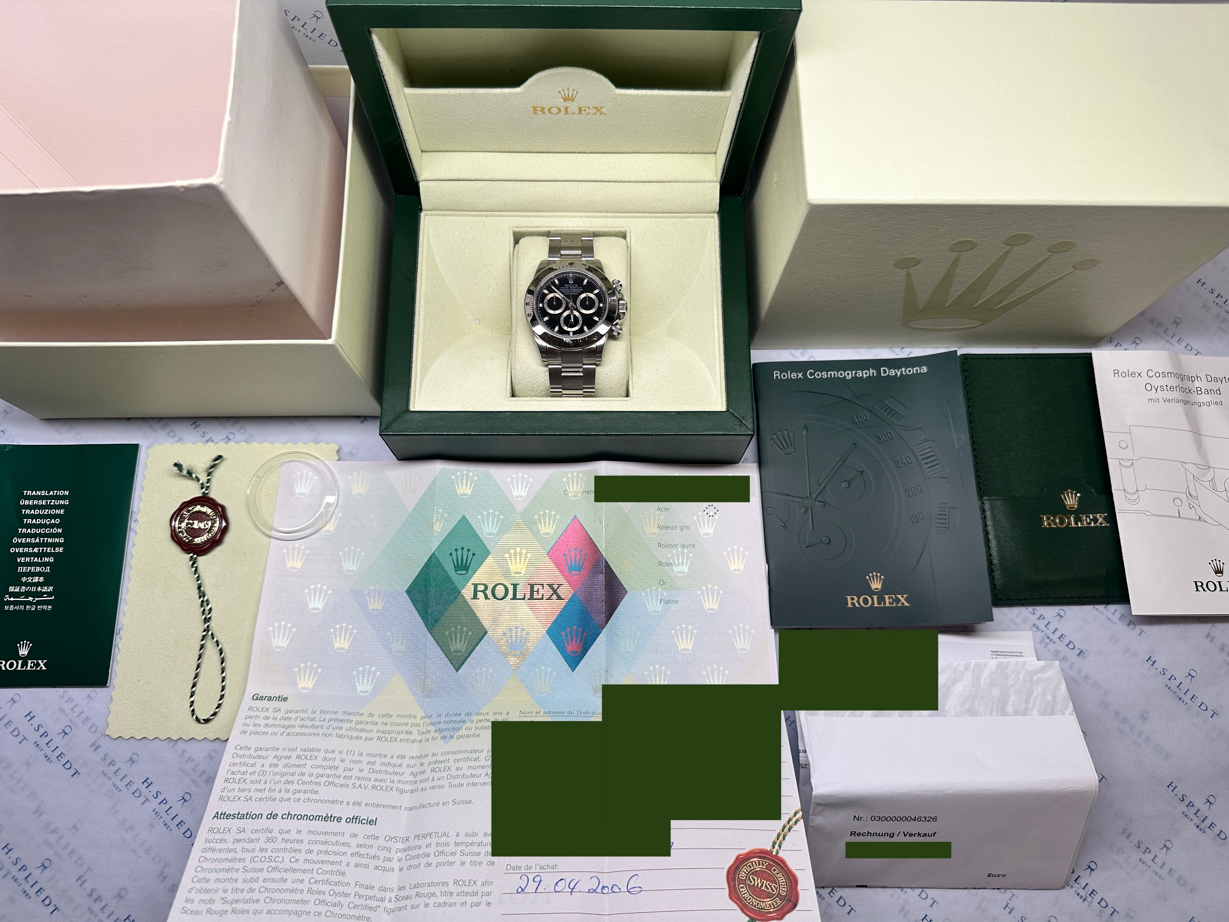 Rolex Daytona 116520 aus Edelstahl mit schwarzem Zifferblatt, geöffneter Box, Papieren und Siegel