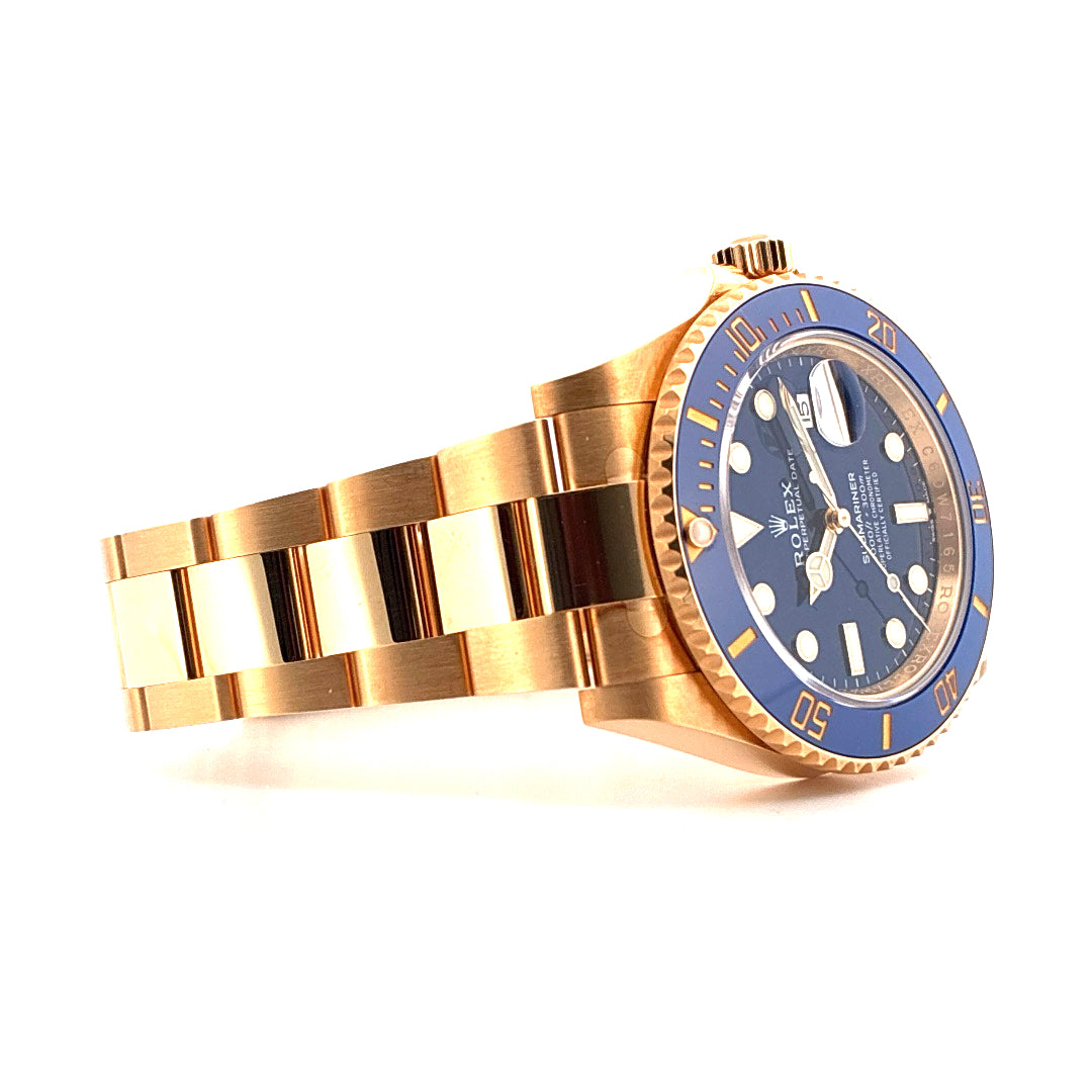 Rolex Submariner Date Gelbgold mit blauem Zifferblatt und Keramiklünette von der Seite auf weißem Hintergrund