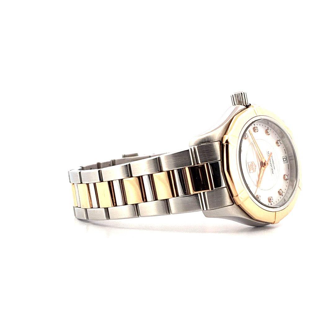 Seitenansicht einer Tag Heuer Aquaracer mit bicolor-Armband aus Stahl und Gelbgold und silbernem Zifferblatt