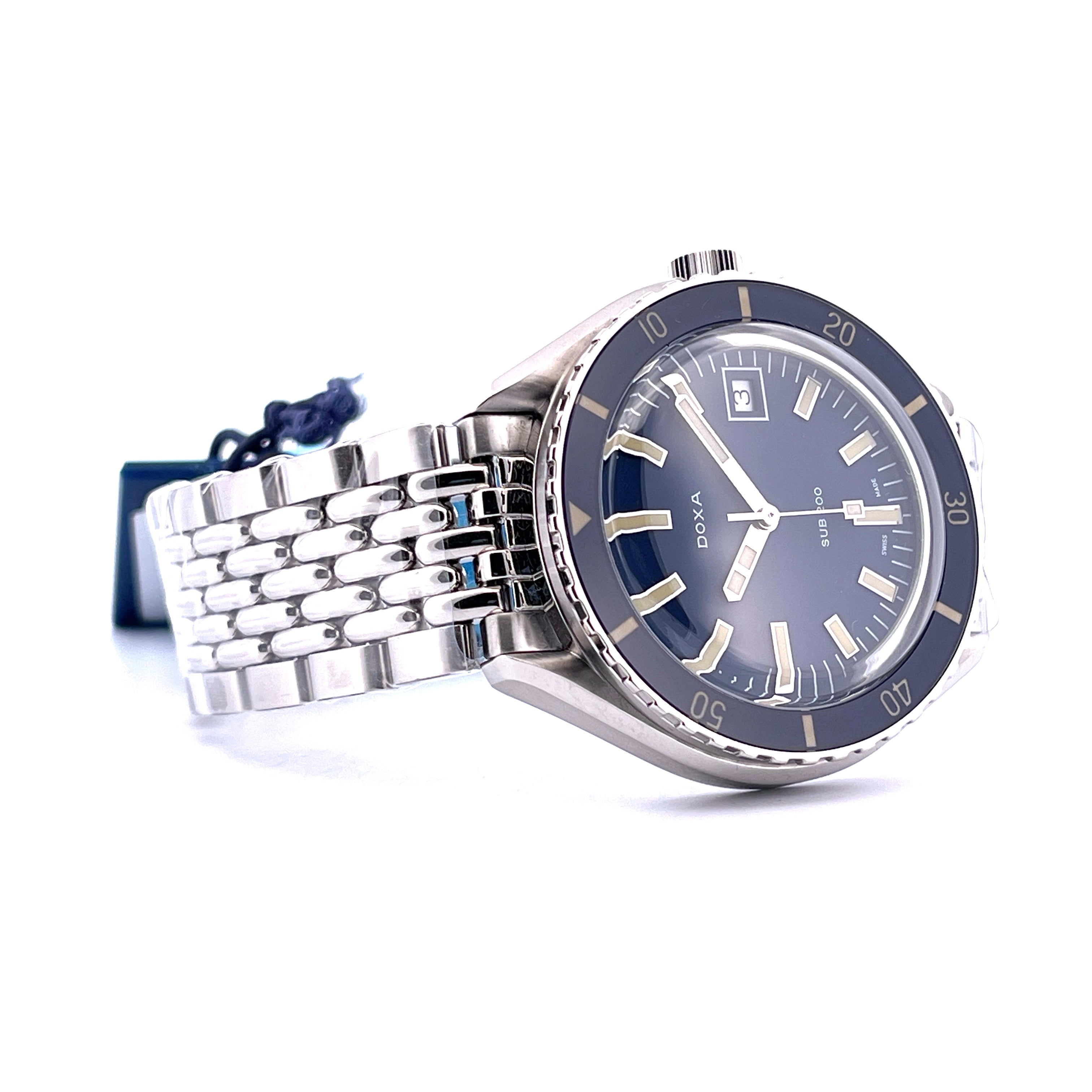 Eine Doxa Sub 200 Caribbean Blue Automatik-Uhr in Nahaufnahme mit silbernem Armband und blauem Zifferblatt