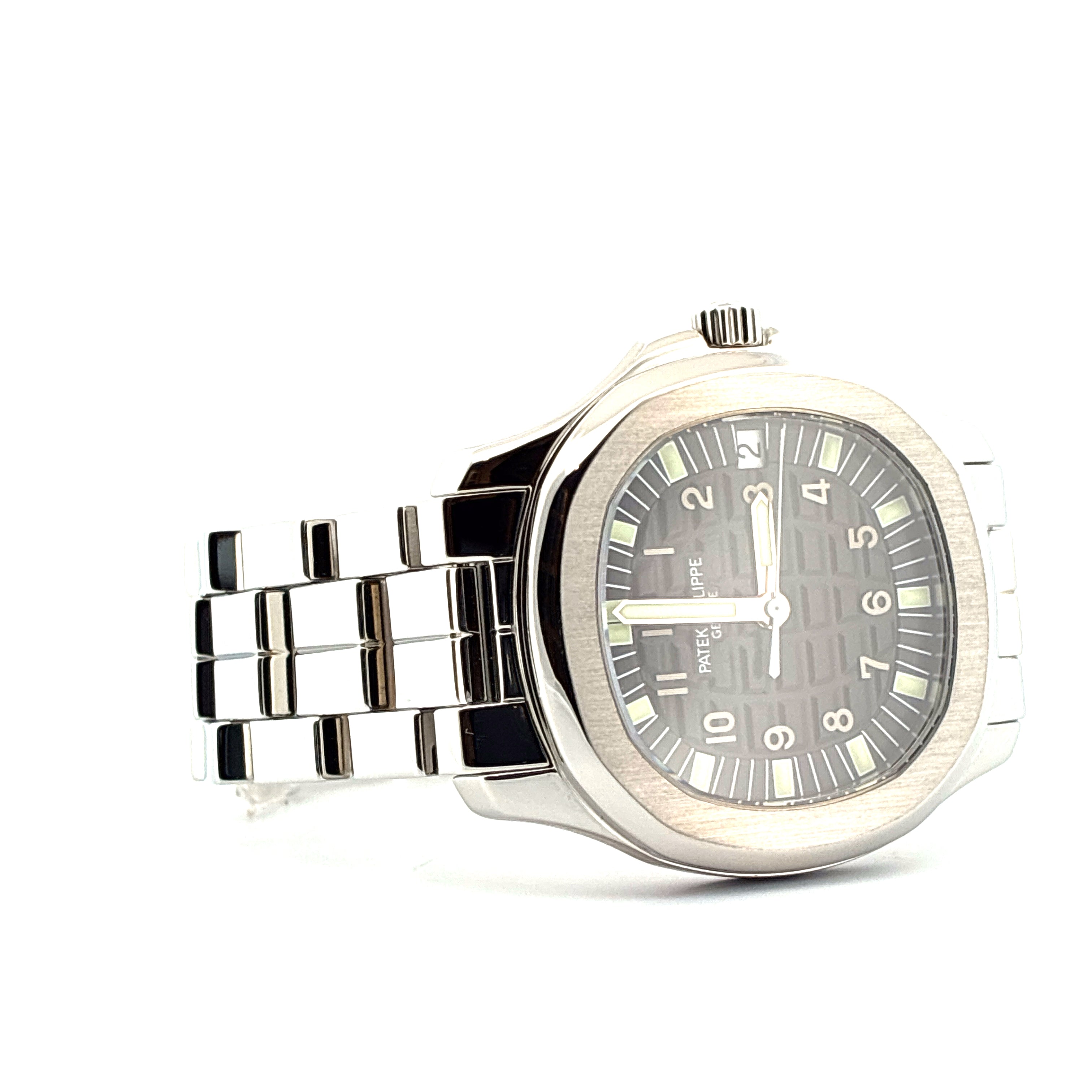 Patek Philippe Aquanaut aus Edelstahl mit grauem Zifferblatt und poliertem Metallarmband auf weißem Hintergrund