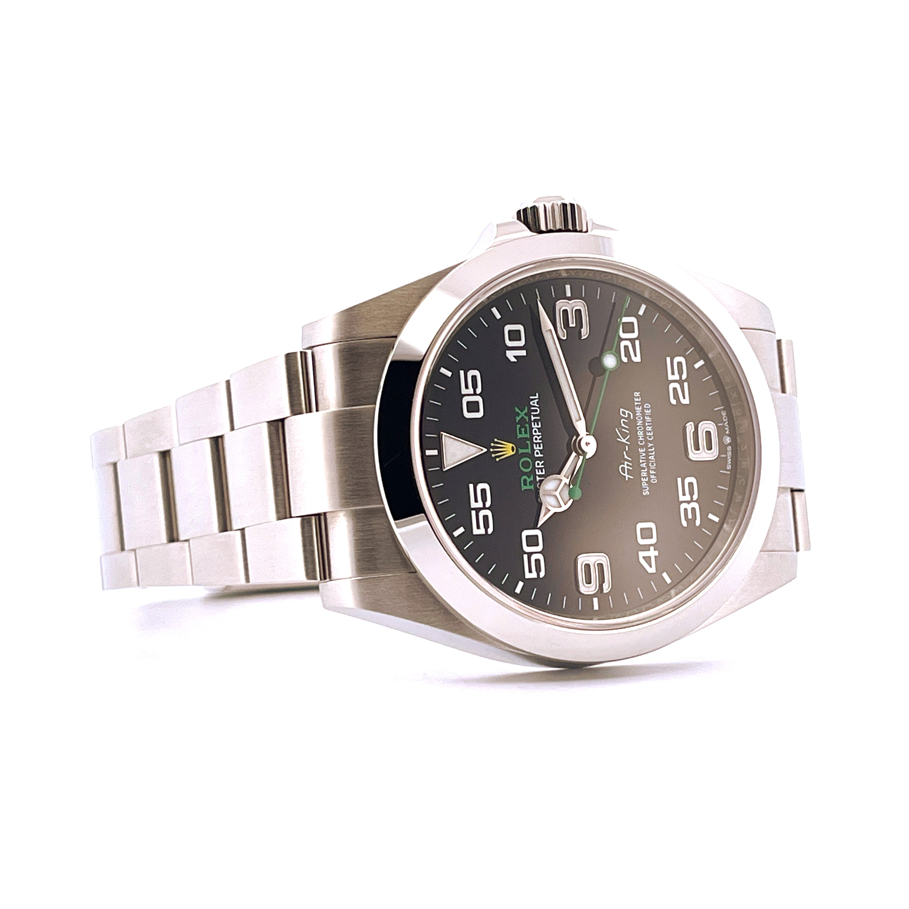 Rolex Air King 126900 im Detail, Stahlgehäuse und Armband, schwarzes Zifferblatt mit grünen Akzenten auf weißem Hintergrund