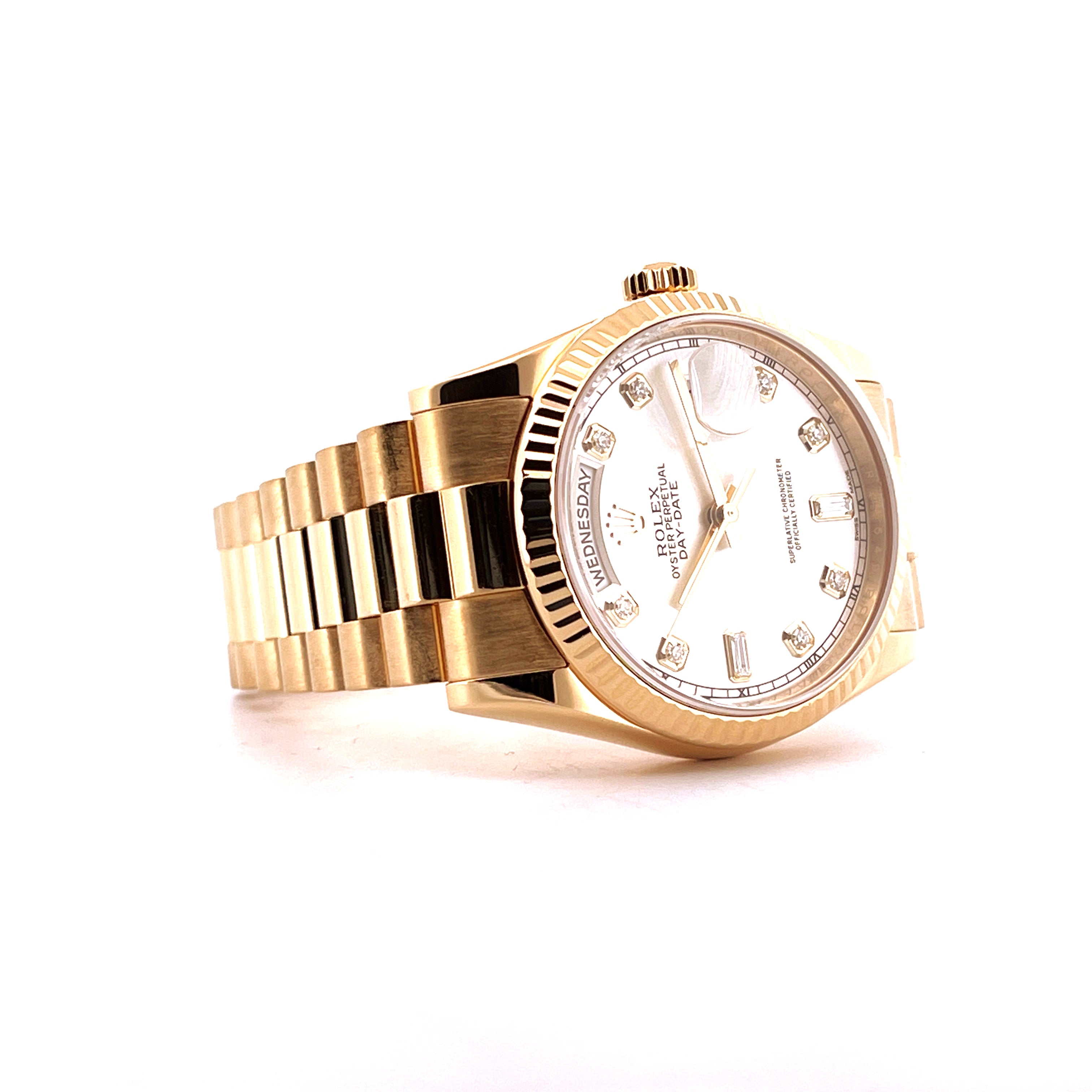 Rolex Day-Date 36 in Gelbgold mit Diamanten, Seitenansicht mit weißem Zifferblatt und sichtbarem Datumsanzeige auf weißem…