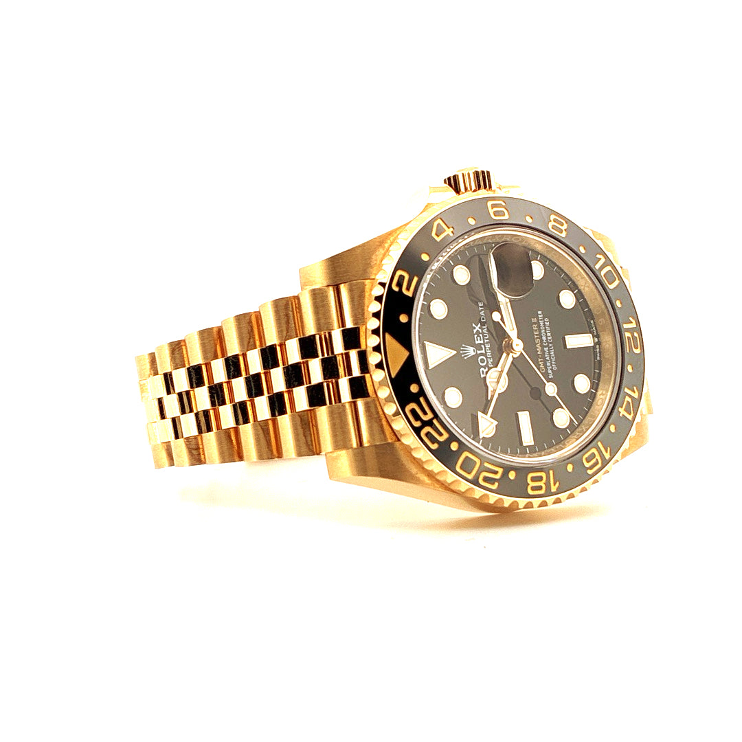 Rolex GMT-Master II 126718GRNR Gelbgold, von schräg oben aufgenommen, mit Goldarmband und schwarzer Lünette