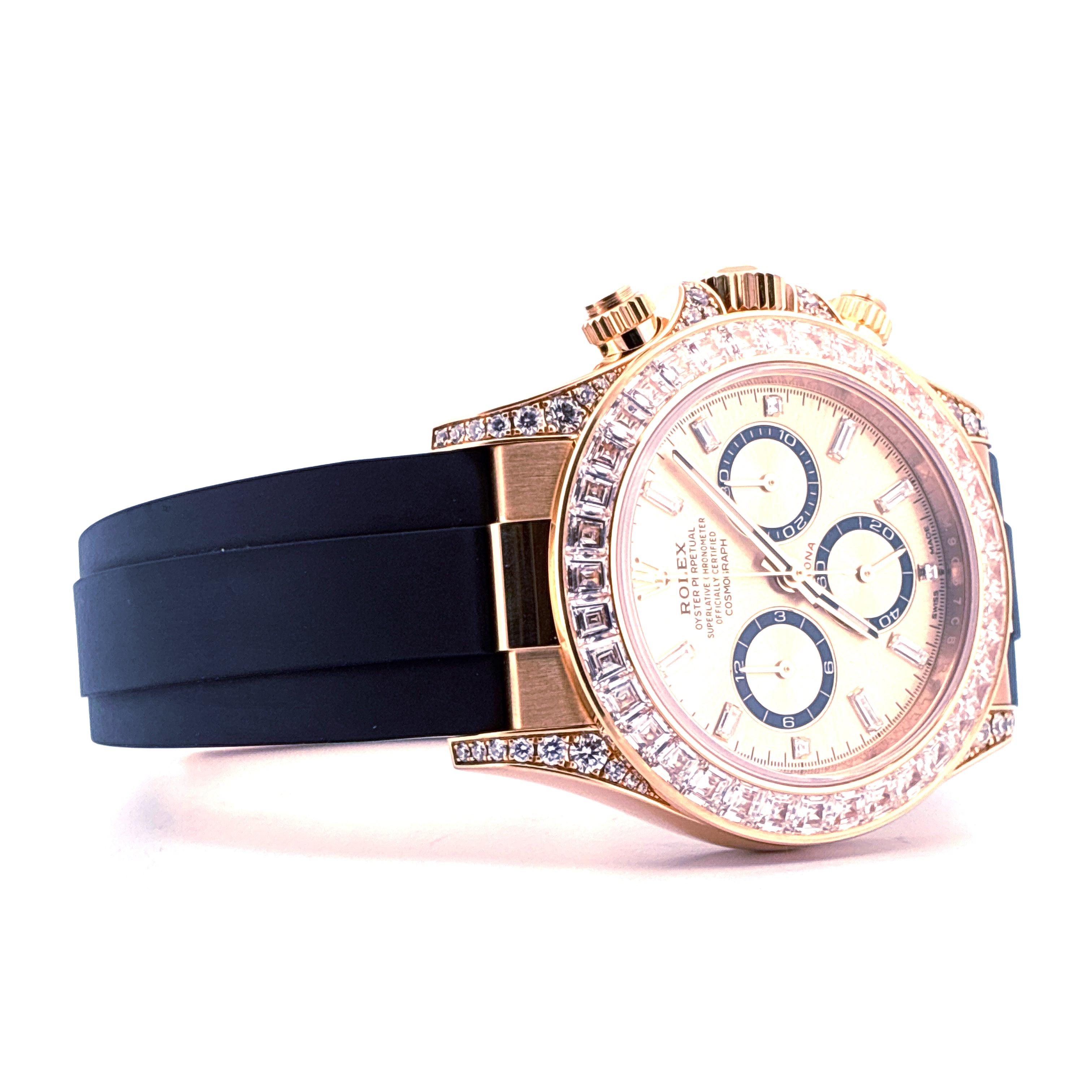Rolex Cosmograph Daytona mit Diamantlünette, goldfarbenem Zifferblatt und schwarzem Armband im Profil, auf weissem Hintergrund