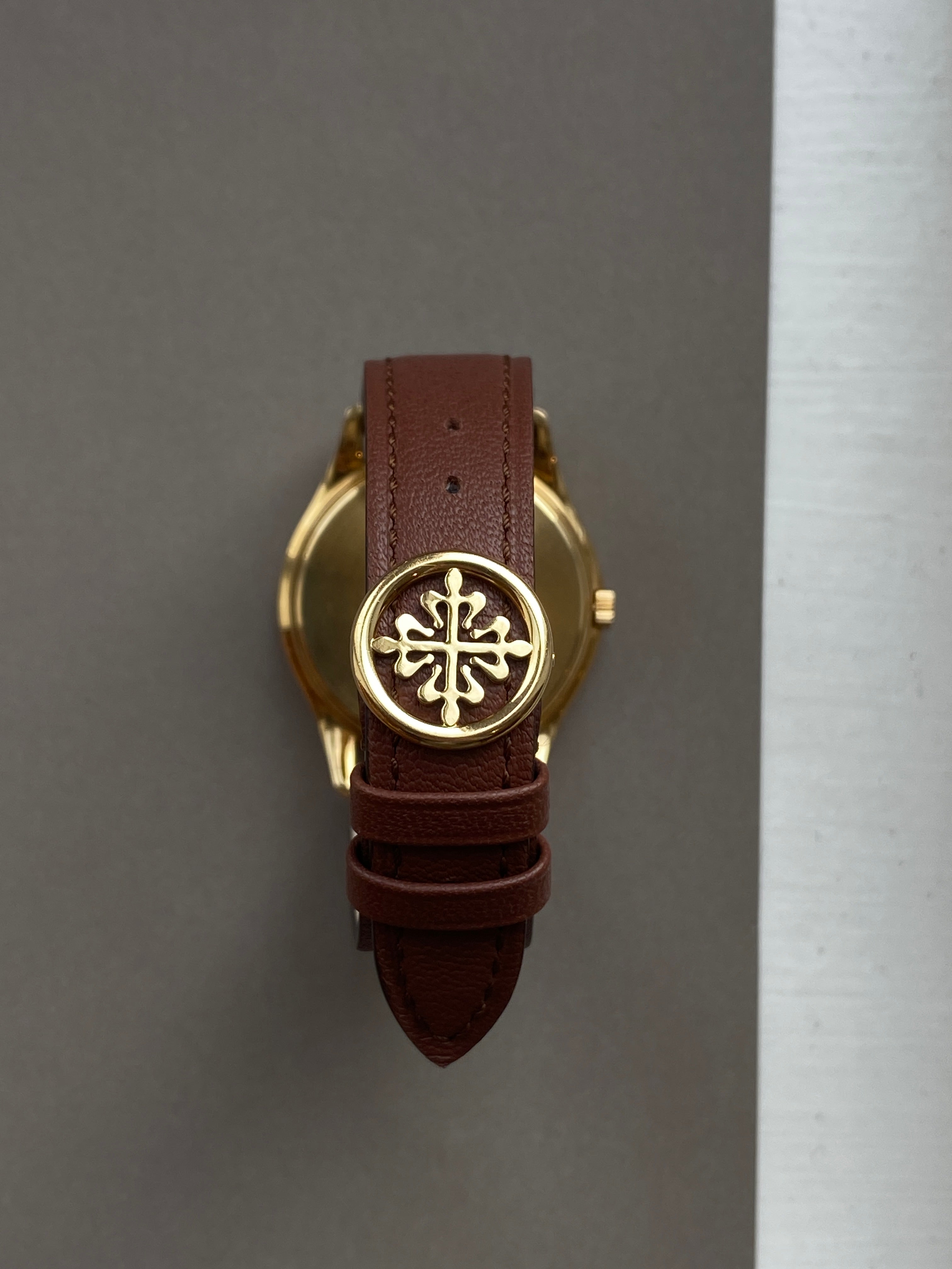 Patek Philippe Perpetual Calendar 3940J-017 im Detail mit braunem Lederarmband und goldenem Patek Philippe Kreuz