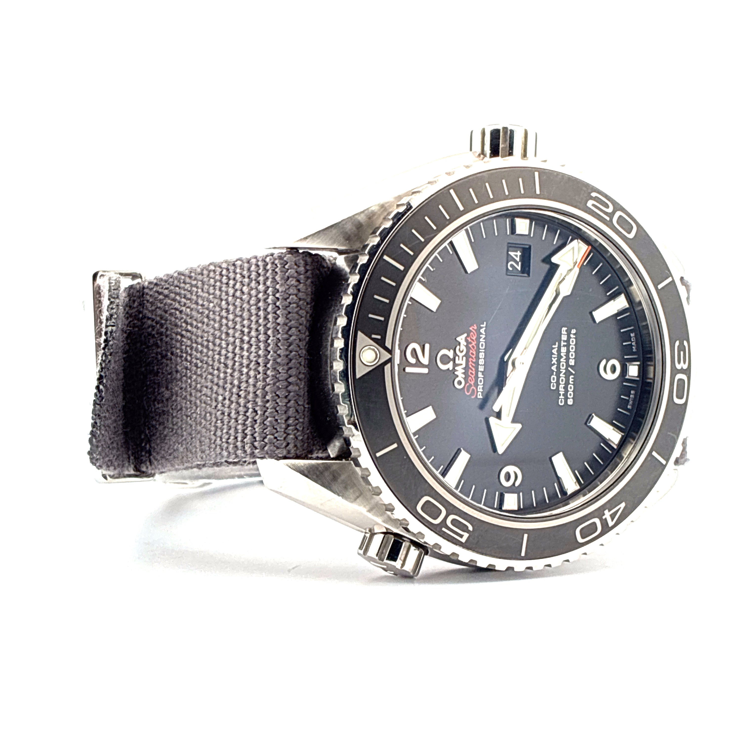Omega Seamaster Planet Ocean mit grauem Textilarmband im Profil vor weissem Hintergrund 4 Zeiger 1 Datumsfenster