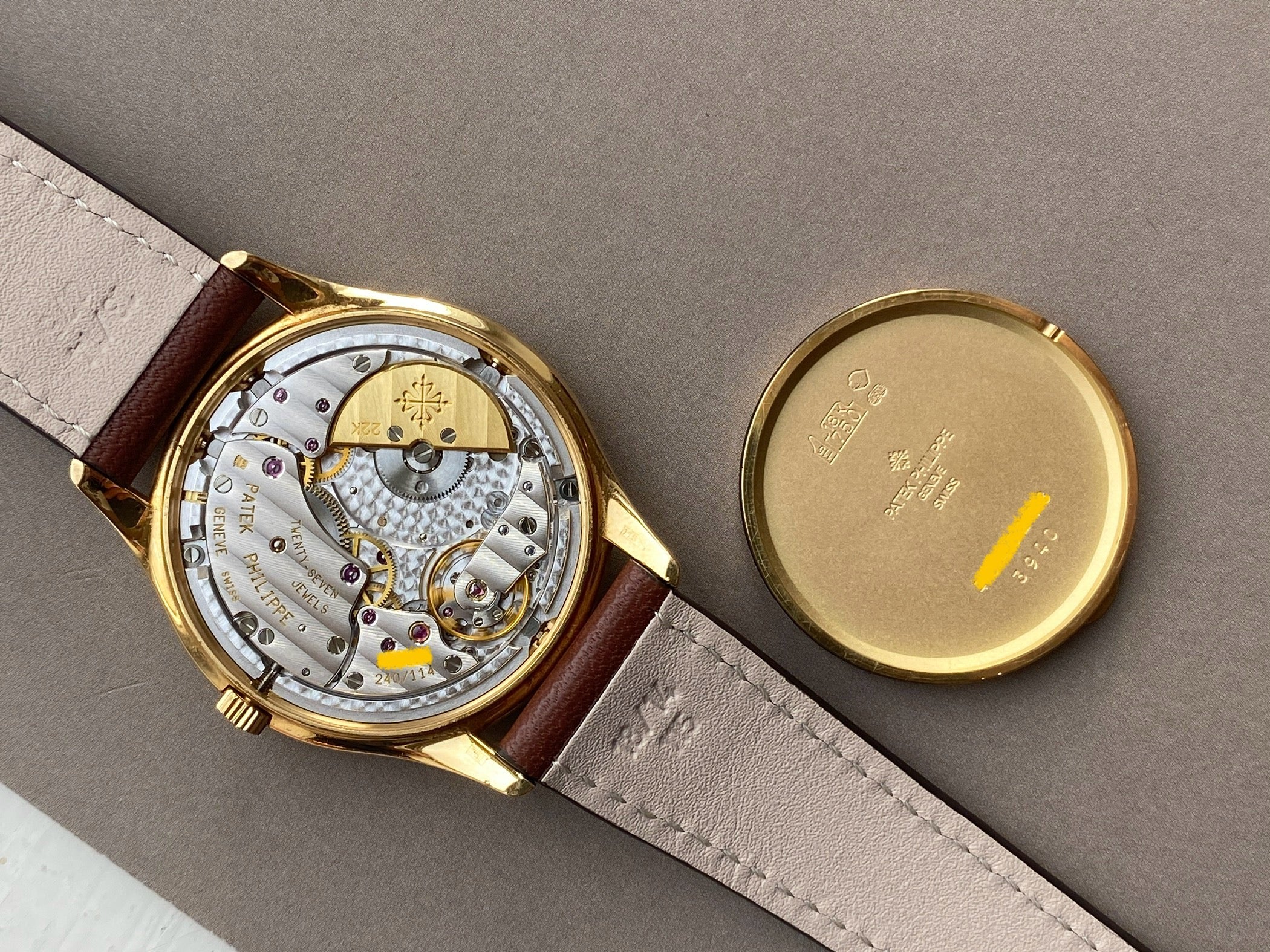 Patek Philippe Perpetual Calendar 3940J-017 Rückseite mit goldenem Gehäuse und Automatikwerk auf grauem Hintergrund