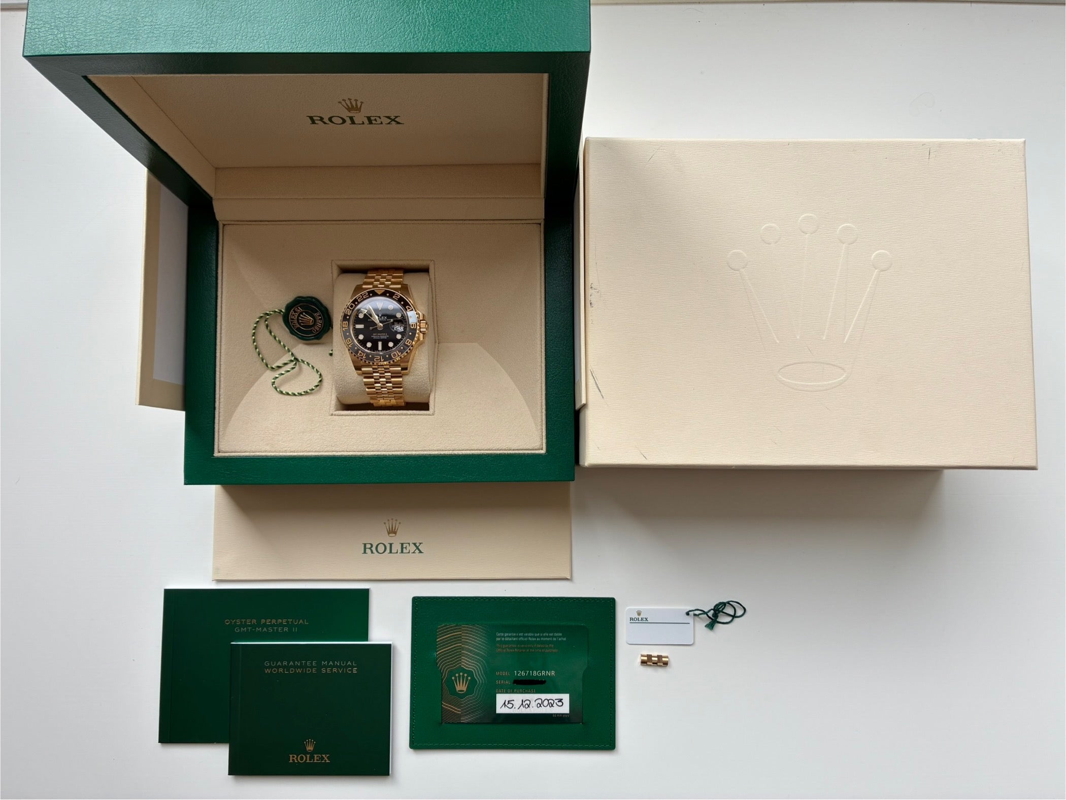 Rolex GMT-Master II 126718GRNR Gelbgold in Box mit Papieren auf weißem Hintergrund