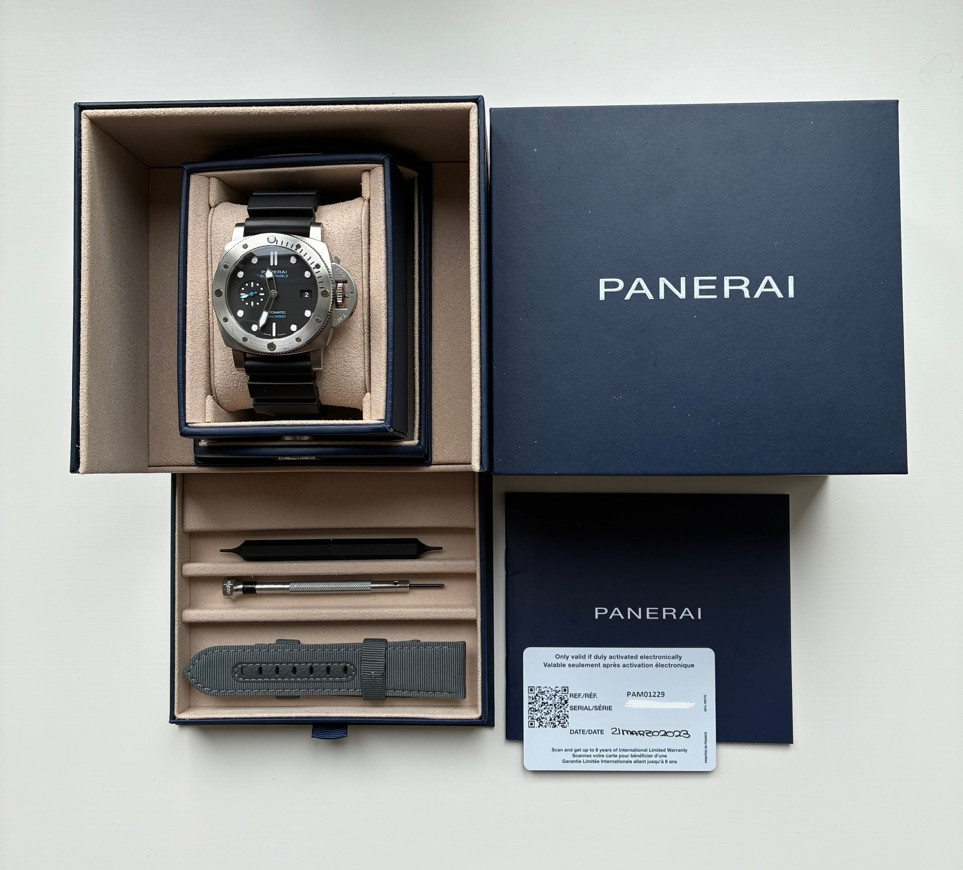Panerai Luminor Submersible Quarantaquattro im geöffneten Karton mit Zubehör und Garantiekarte auf hellem Untergrund