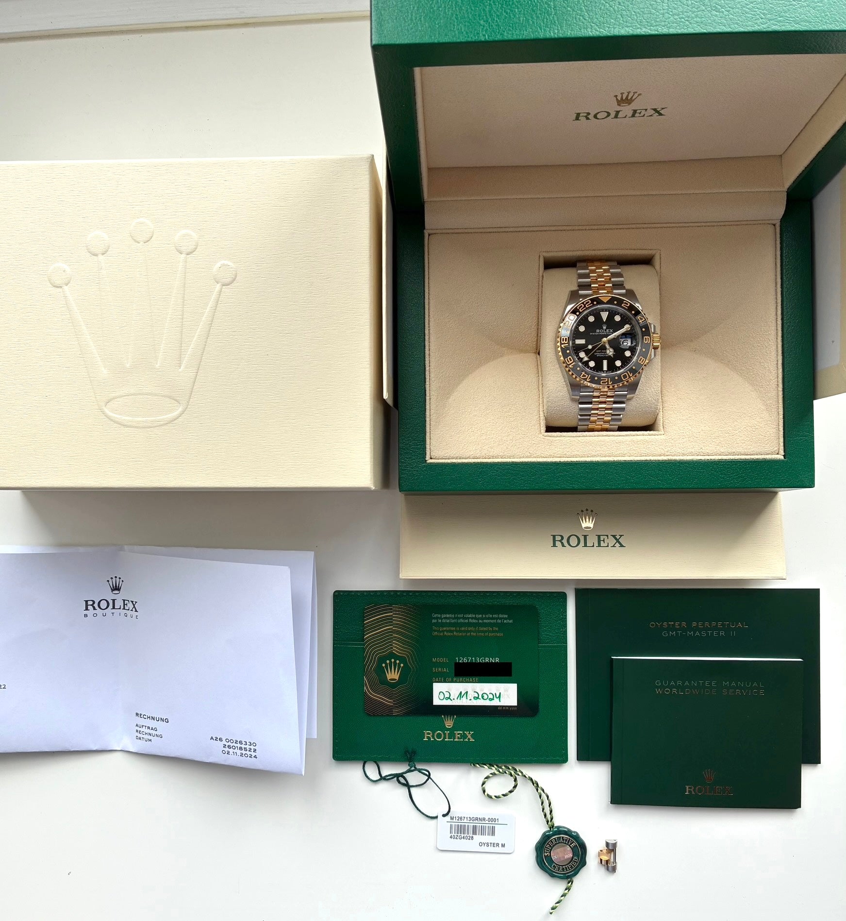 Rolex GMT-Master II Stahl/Gelbgold mit schwarzem Zifferblatt in geöffneter Box mit Dokumenten