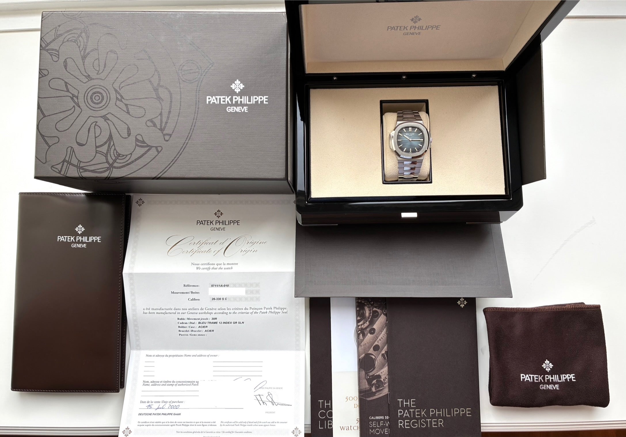 Patek Philippe Nautilus 2020 im geöffneten Kasten mit Papieren und brauner Hülle