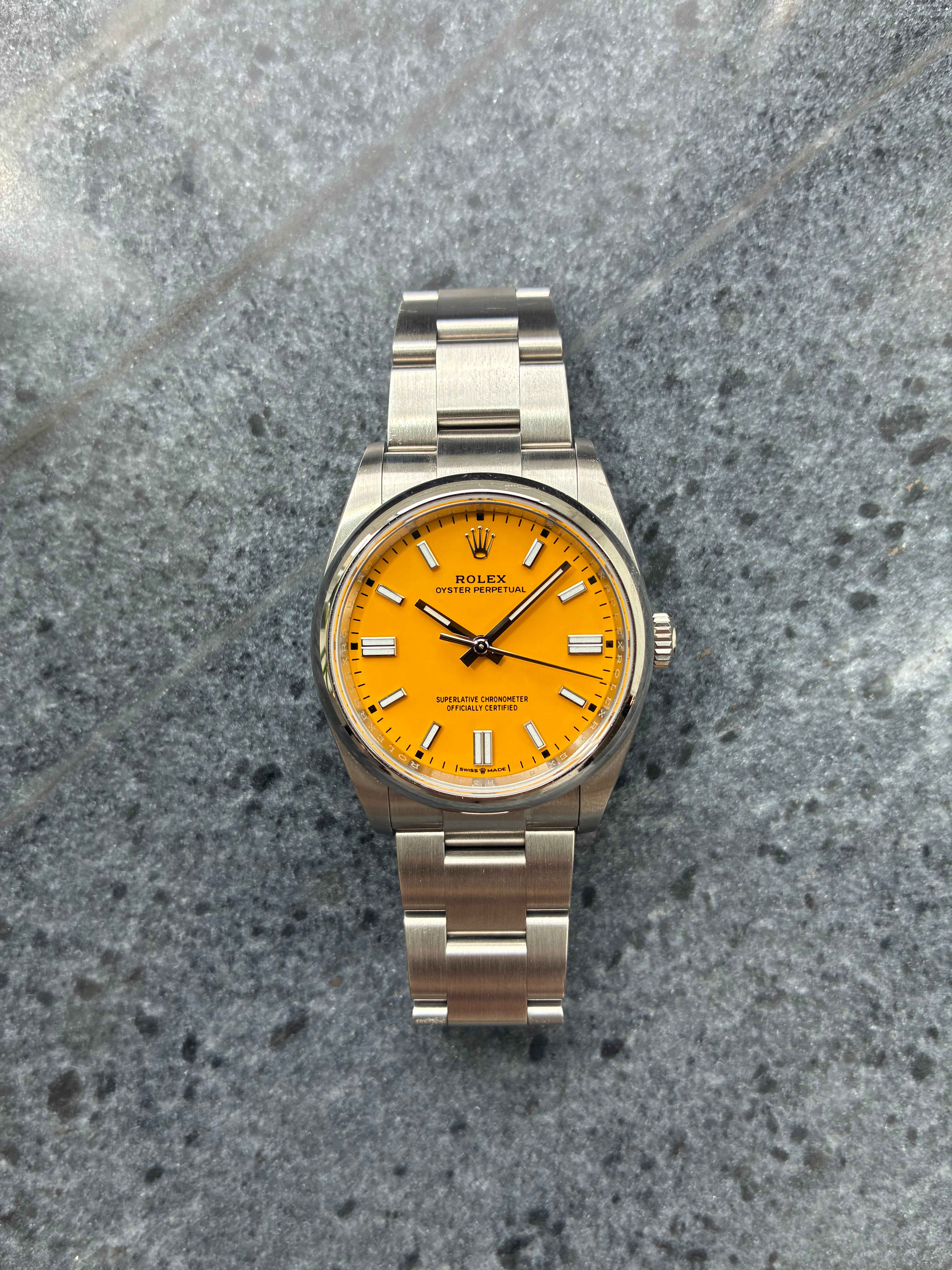 Rolex Oyster Perpetual 36 mit gelbem Zifferblatt aus Stahl mit Edelstahlarmband auf Steinuntergrund