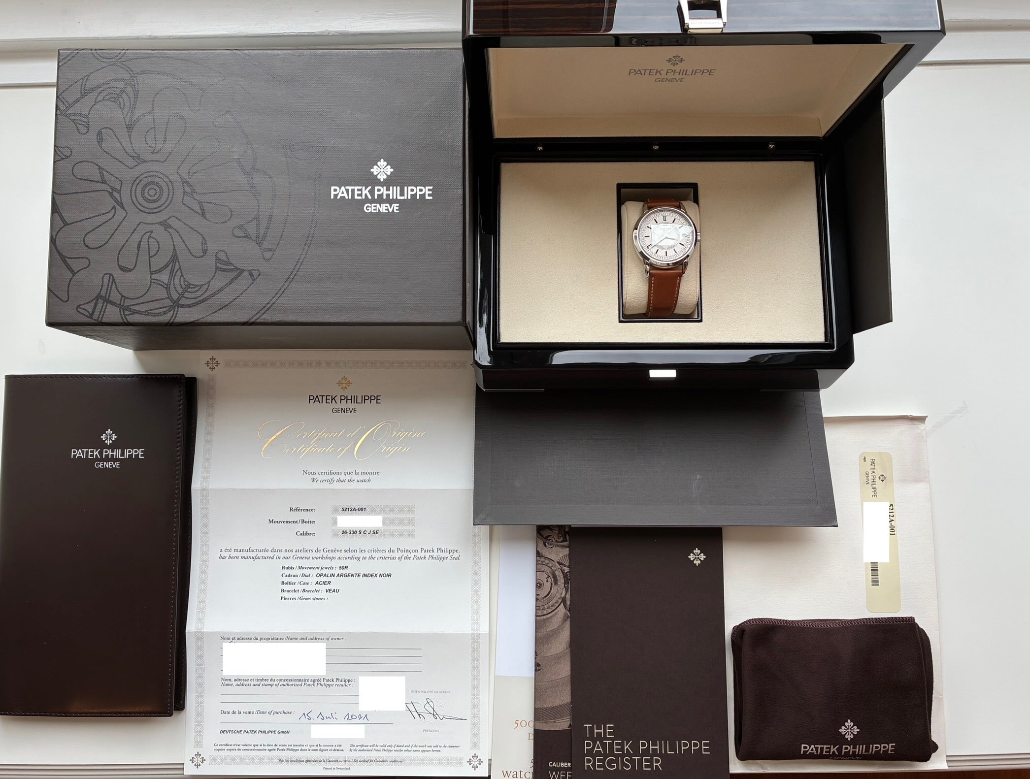 Patek Philippe Calatrava Weekly Calendar 5212A-001 im geöffneten Kasten mit Papieren und brauner Ledermappe