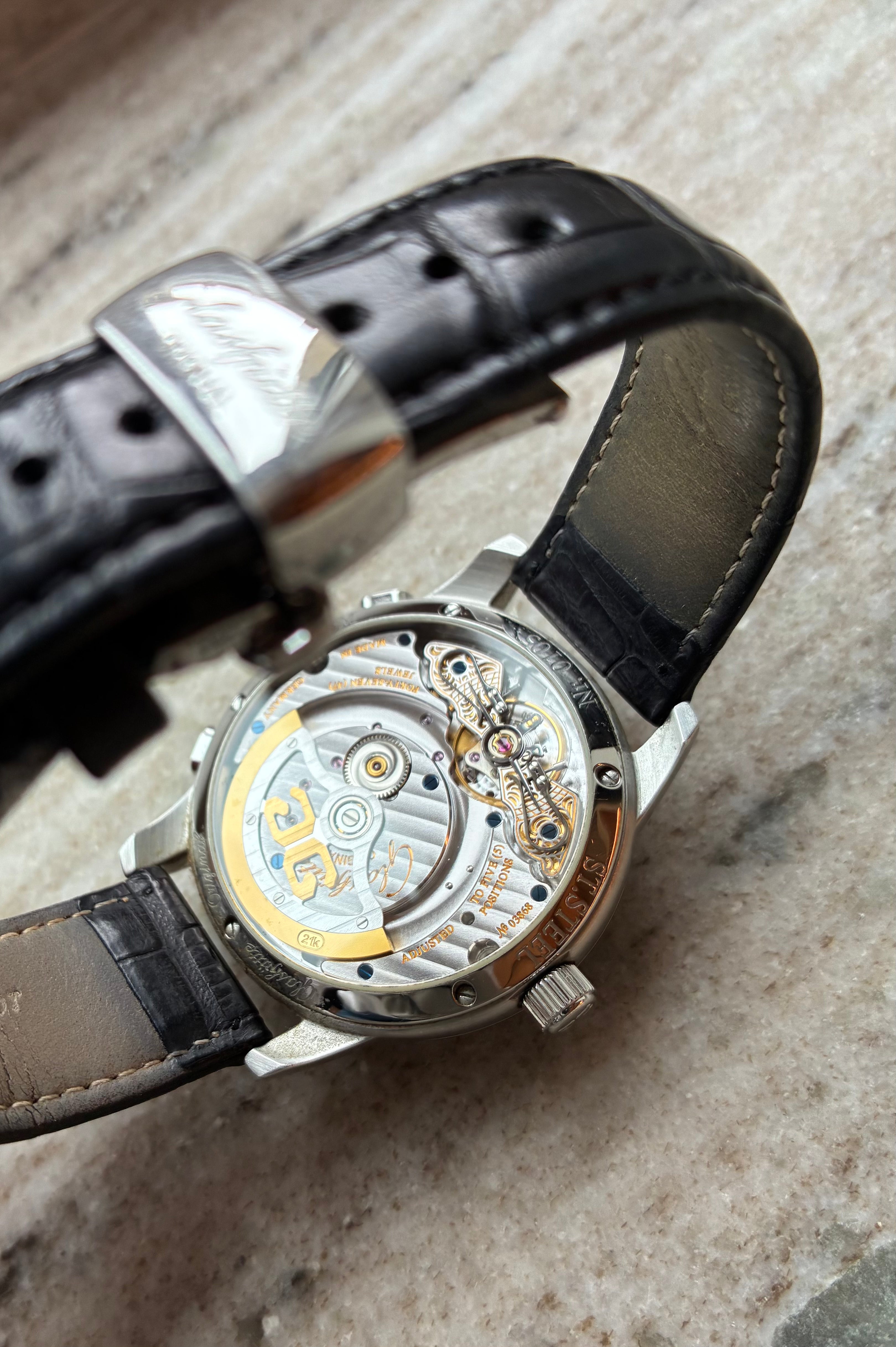 Glashütte Original PanoMatic Venue Rückseite mit Automatikwerk und schwarzem Lederarmband auf marmoriertem Untergrund