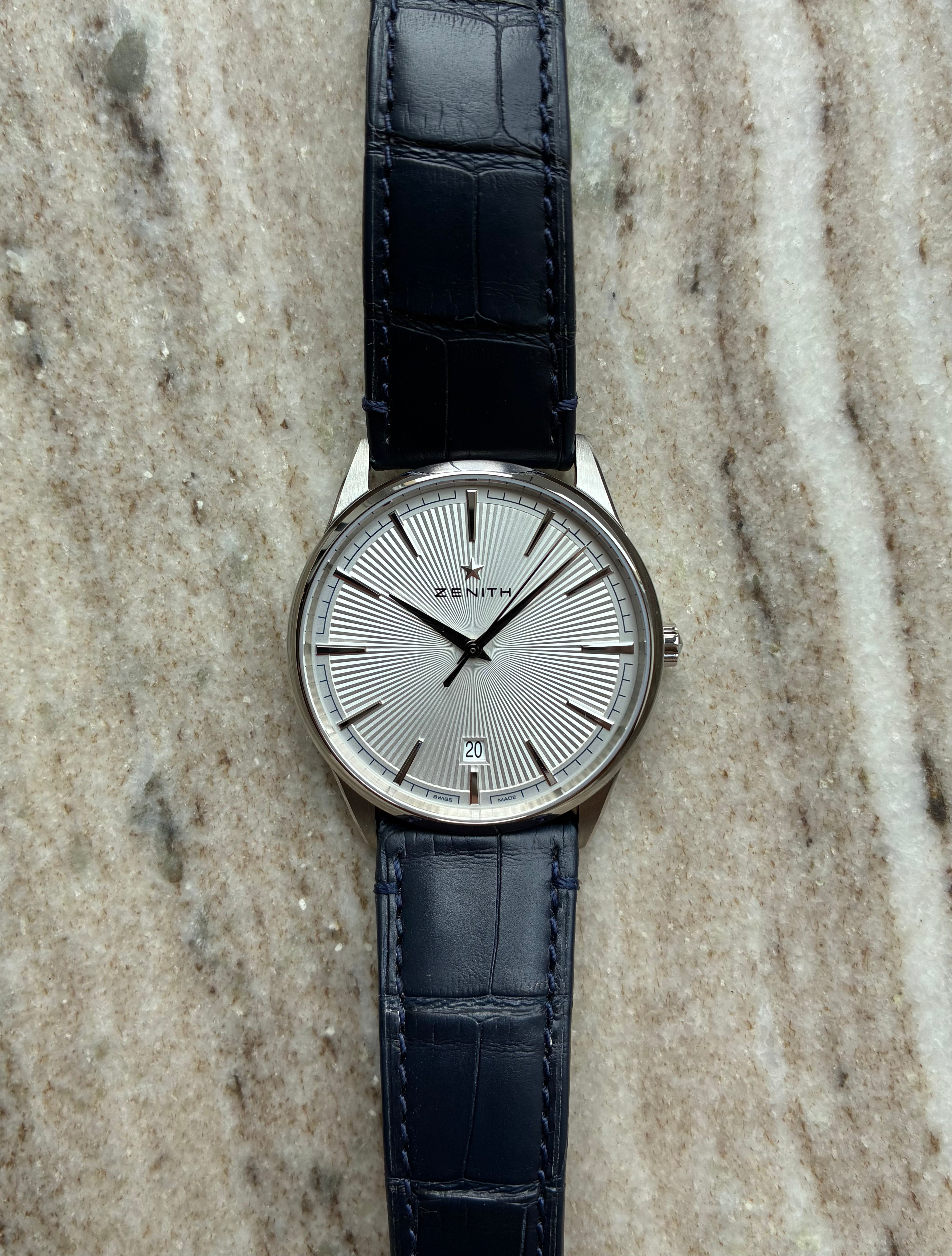 Zenith Elite Classic Automatic Ultra Thin 40 mm mit silbernem Zifferblatt und dunkelblauem Lederarmband auf Marmor