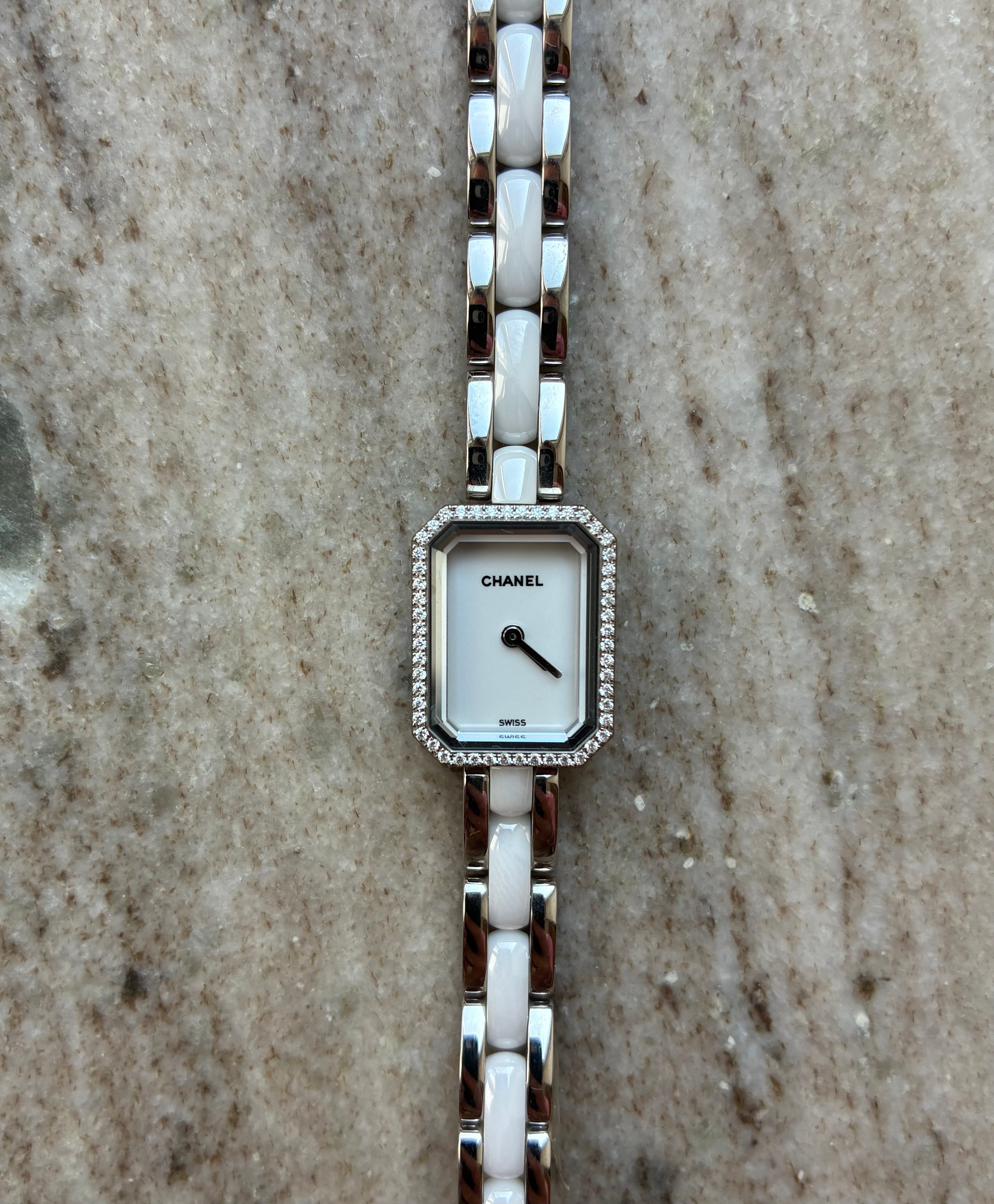 Chanel Première Uhr mit weißem Zifferblatt, Diamantlünette und Edelstahl-Keramik-Armband auf Marmor