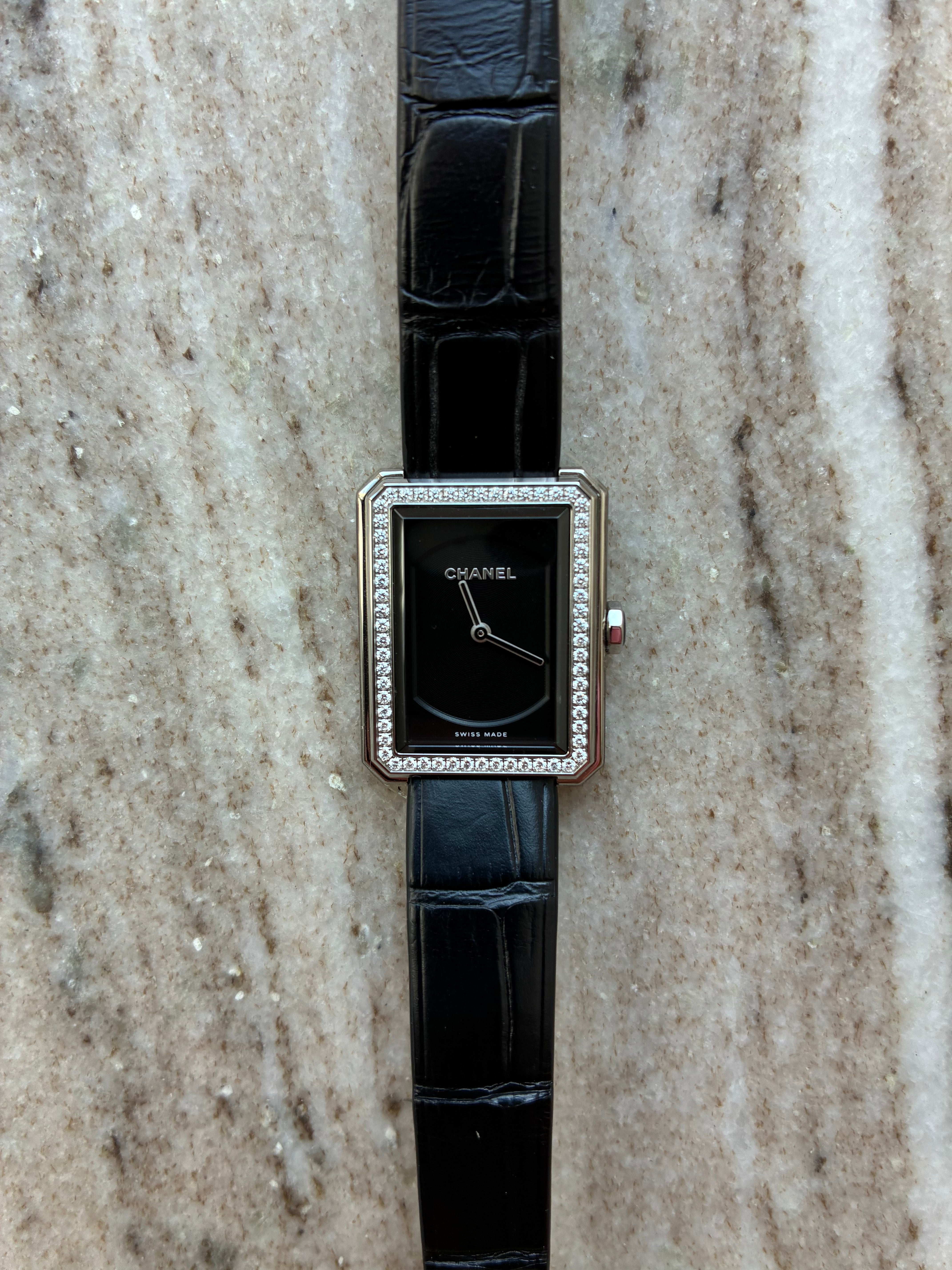 Chanel Boyfriend Uhr mit Diamanten und schwarzem Lederband auf Marmoruntergrund