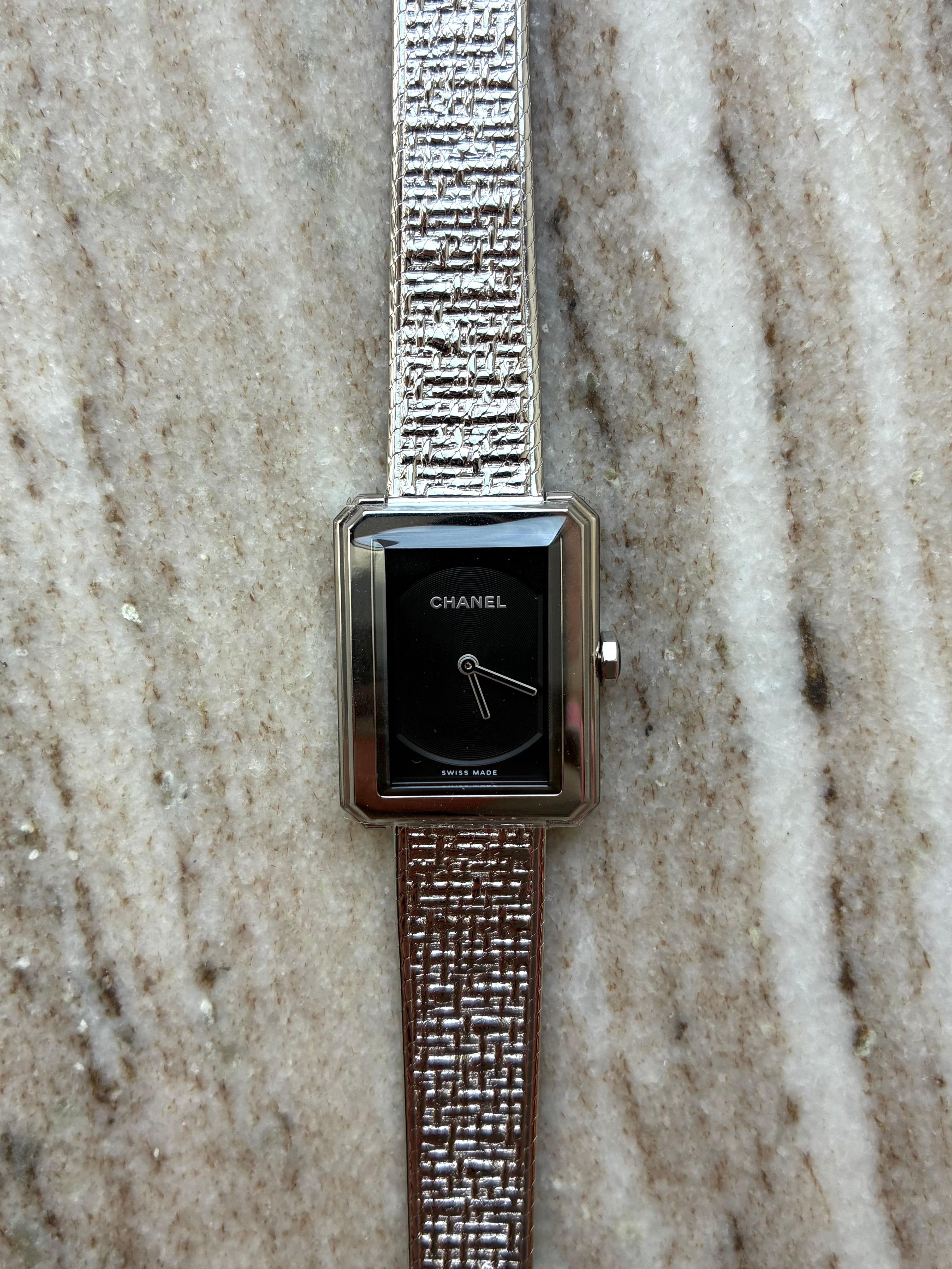 Chanel Boyfriend Damenuhr aus Edelstahl mit schwarzem Zifferblatt und auffälligem Armband auf Marmoruntergrund