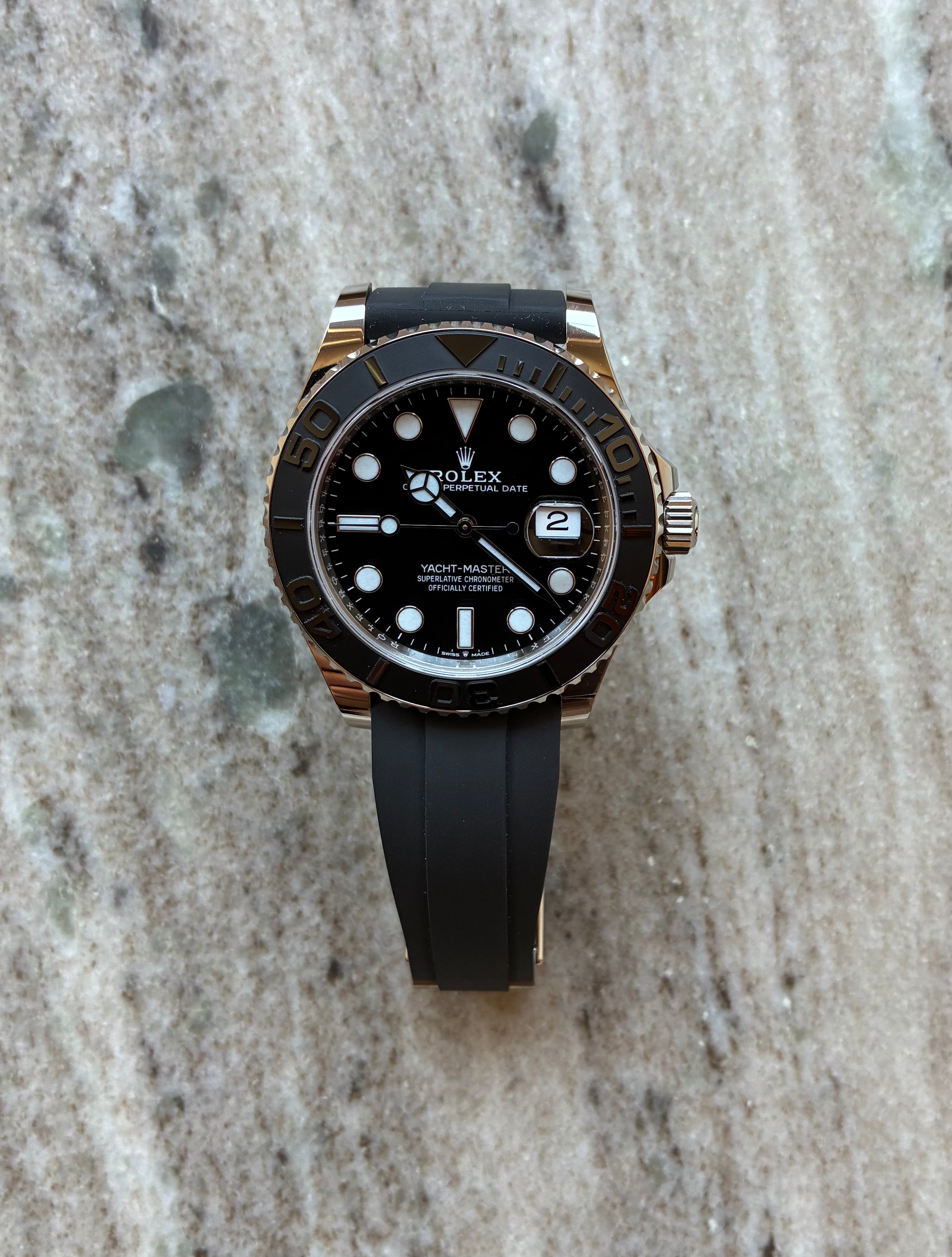 Rolex Yacht-Master 42mm mit schwarzem Zifferblatt und Kautschukband auf Marmor