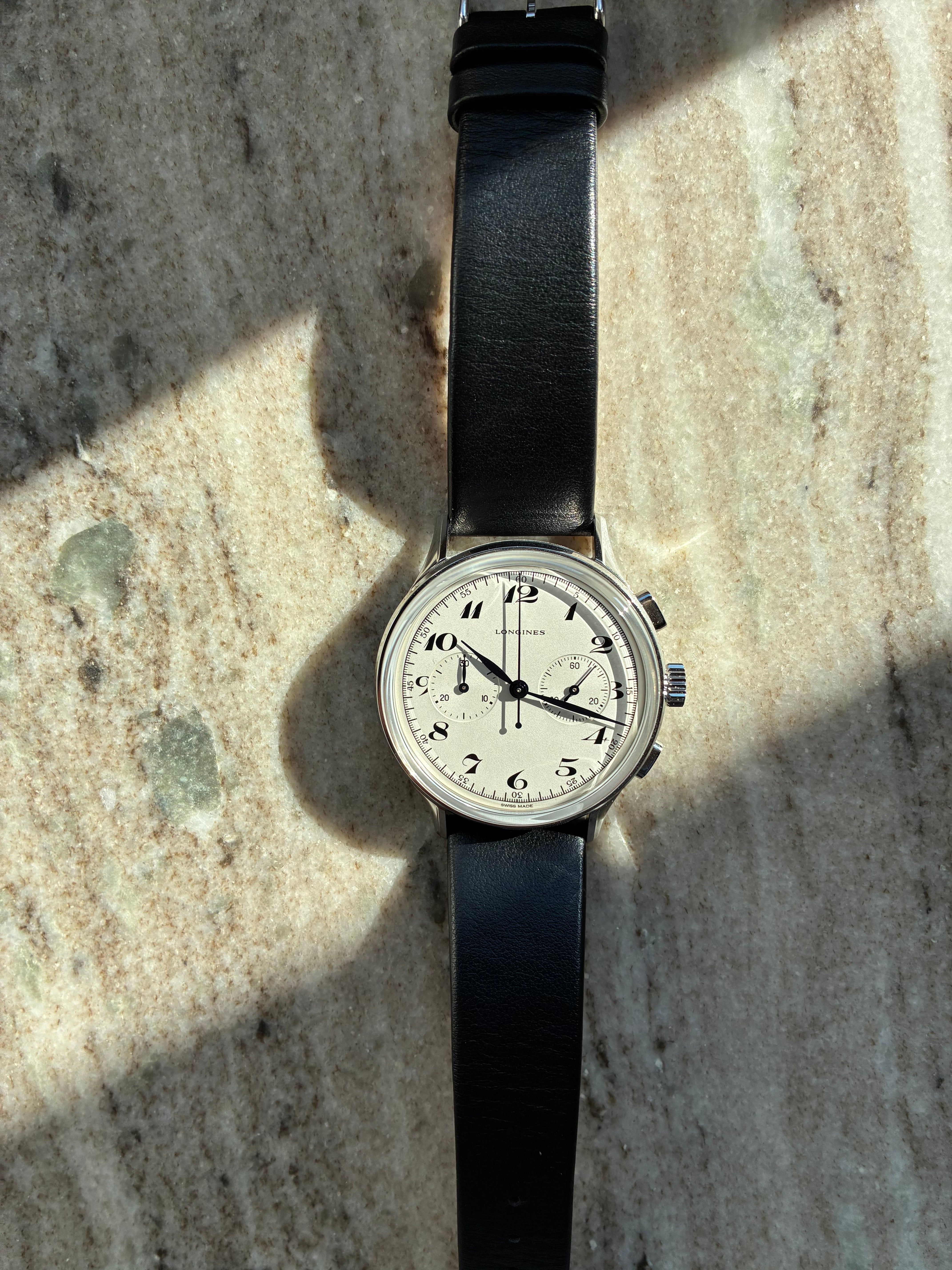 Longines Heritage Classic Automatik Chronograph mit schwarzem Lederarmband auf Marmor Hintergrund