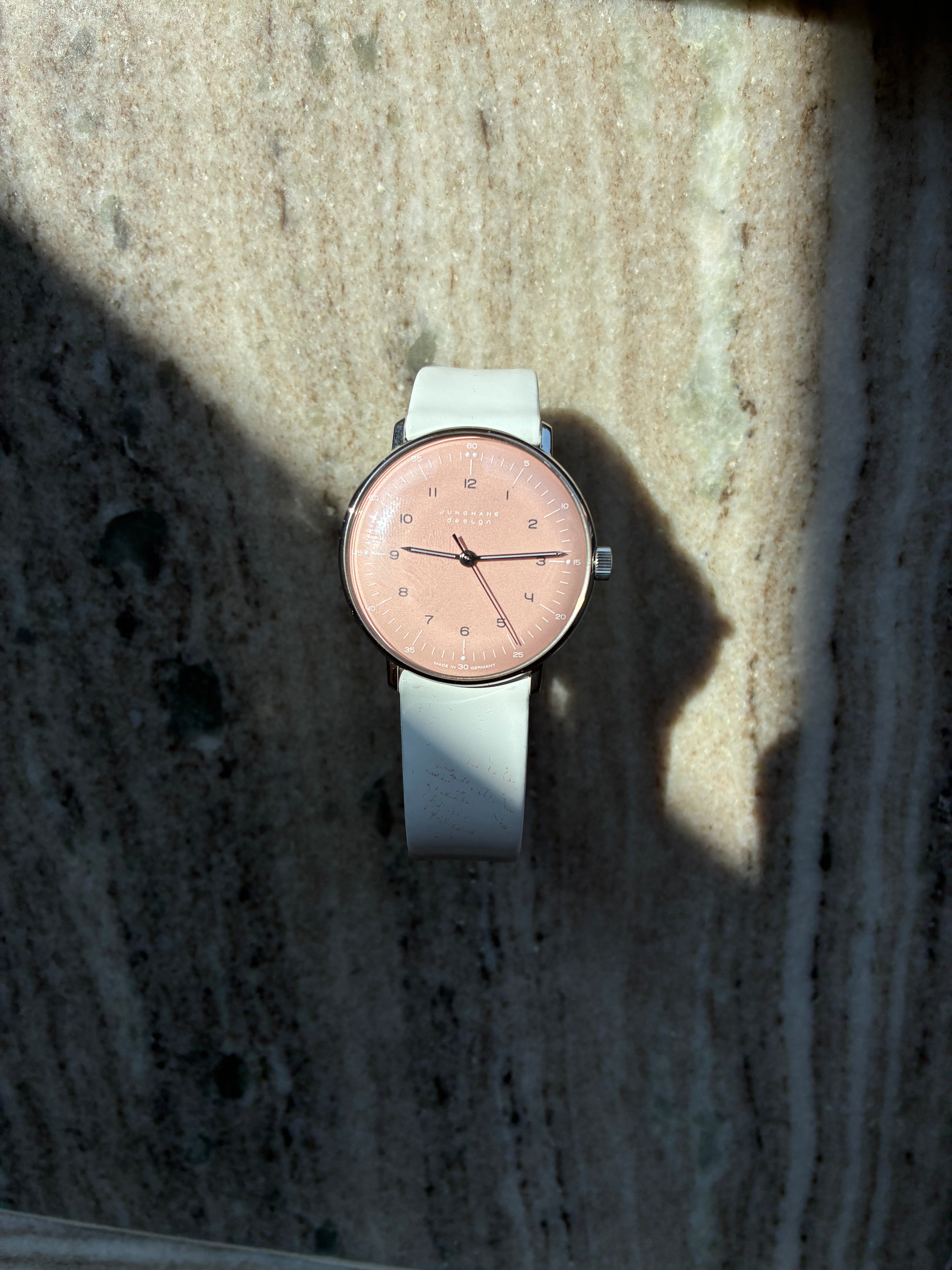 Junghans Max bill Handaufzug rosa Zifferblatt mit weißem Lederarmband auf Marmoruntergrund