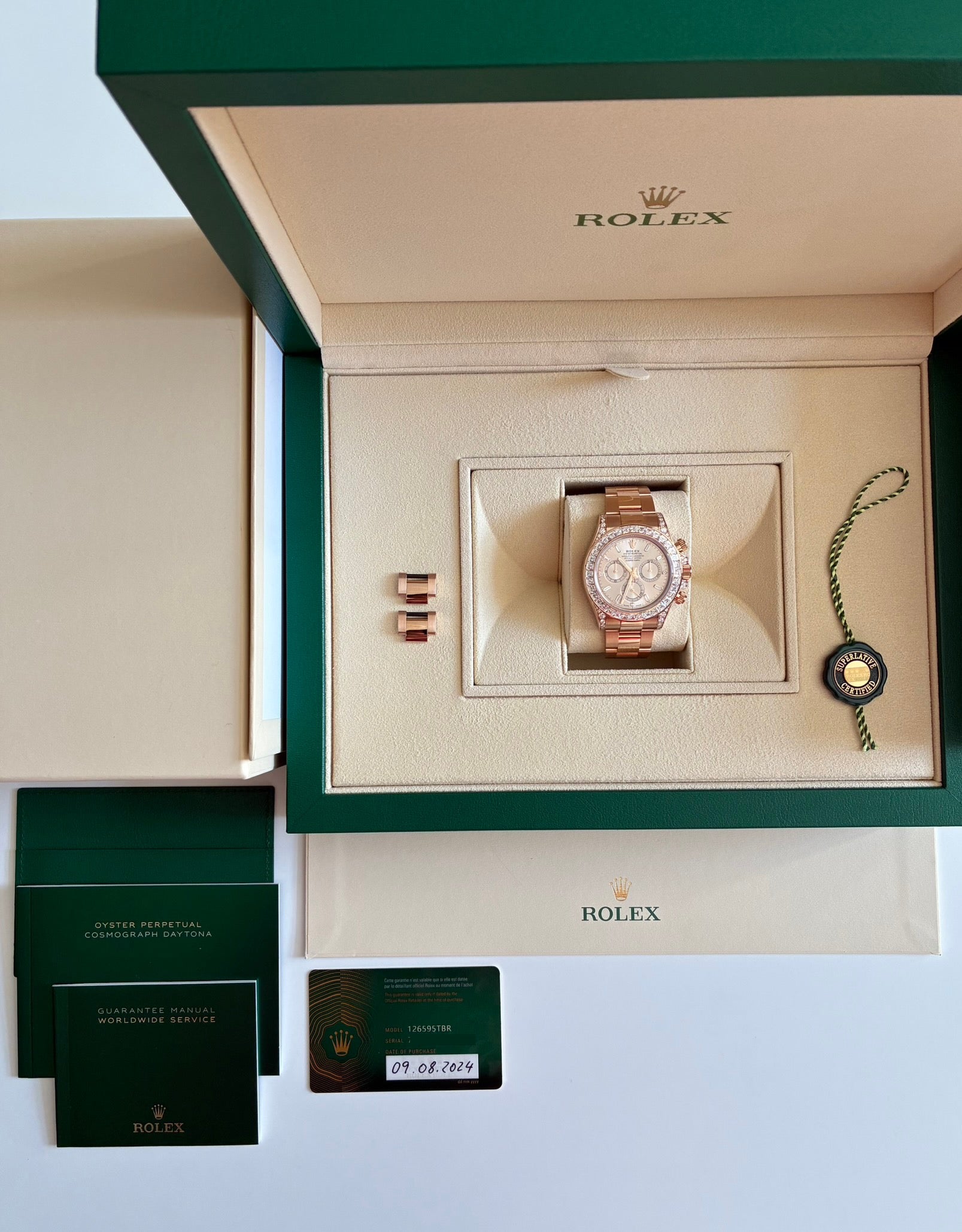 Rolex Daytona Roségold mit Diamanten und Anleitung in geöffneter grüner Box