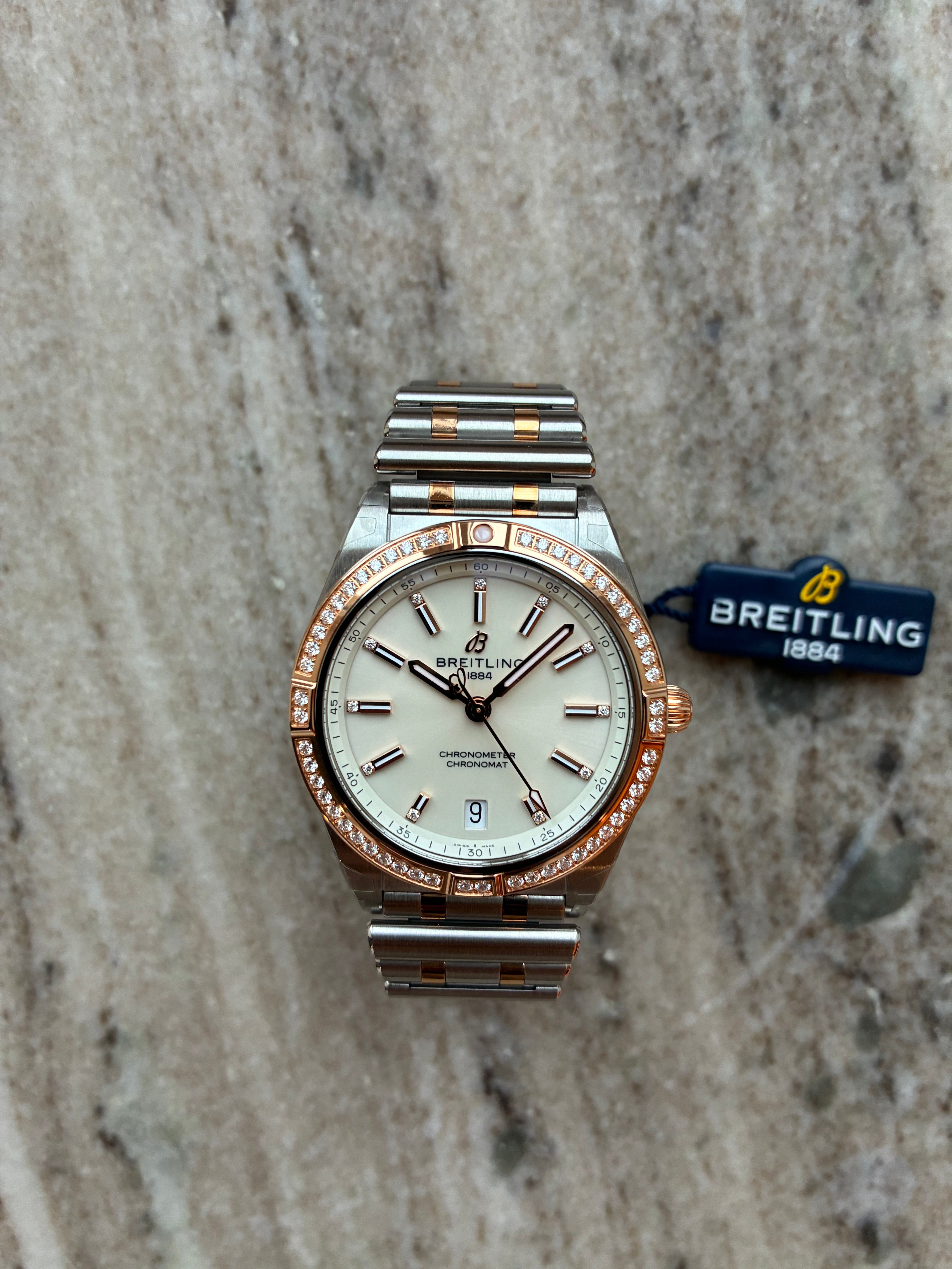 Breitling Chronomat Lady 36mm Automatik mit Zifferblatt und Edelstahlband auf Marmor Hintergrund