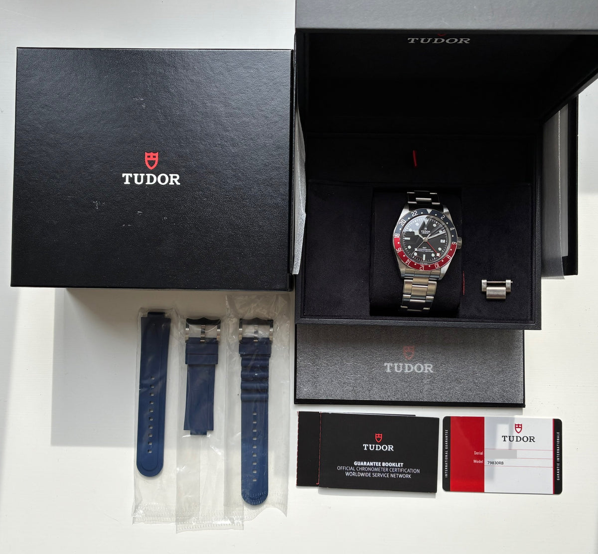 Tudor Heritage Black Bay GMT (2020), Gesamtansicht mit Box, Zifferblatt und Unterlagen vor weißem Hintergrund