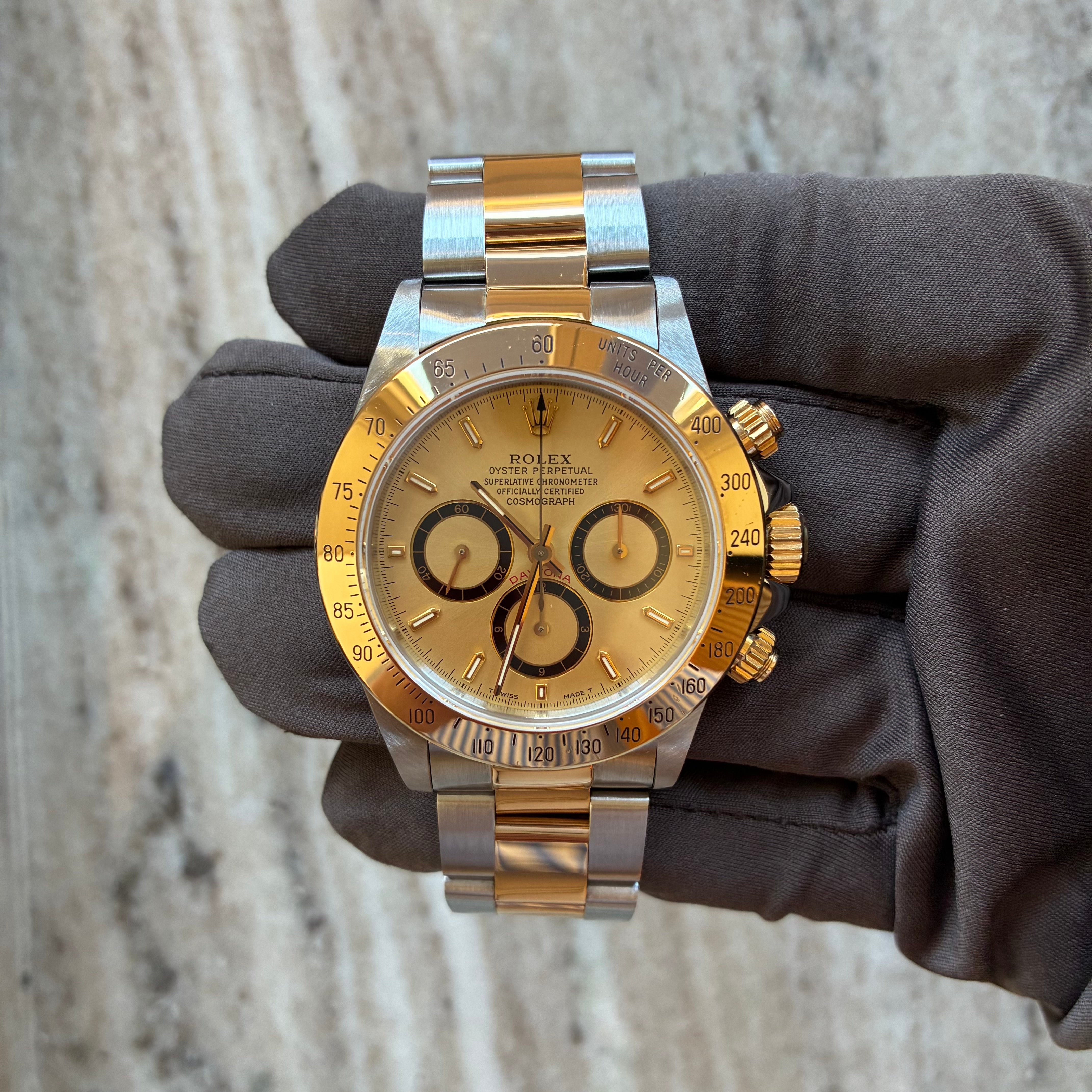 Rolex Daytona Bicolor (1991) Automatikuhr im Frontalansicht auf einem grauen Handschuh mit sichtbaren Zifferblatt, Zeigern und Armband