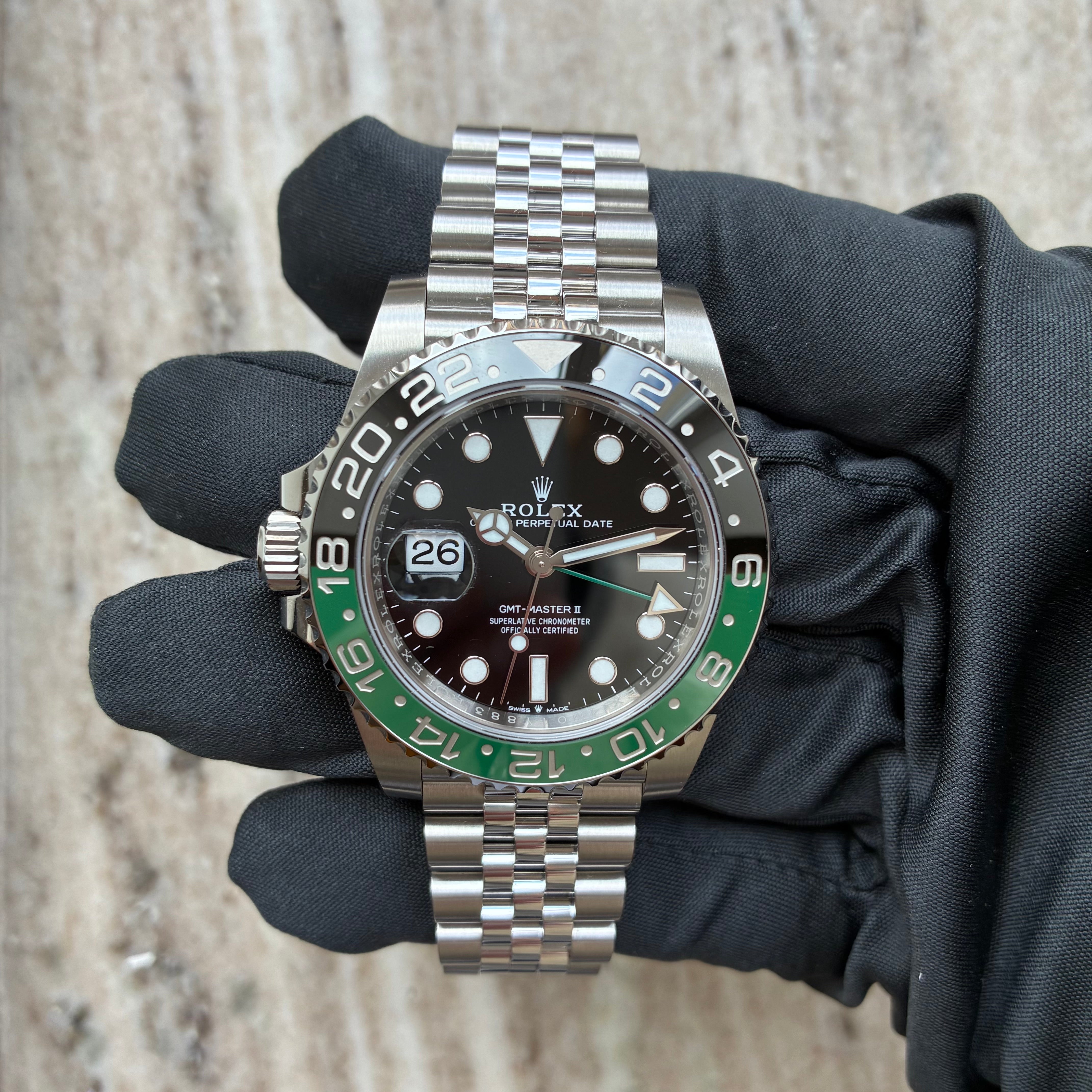 Rolex GMT-Master II Lefthand mit schwarzem Zifferblatt und grüner Luenette, gehalten von einer schwarzen Handschuhhand