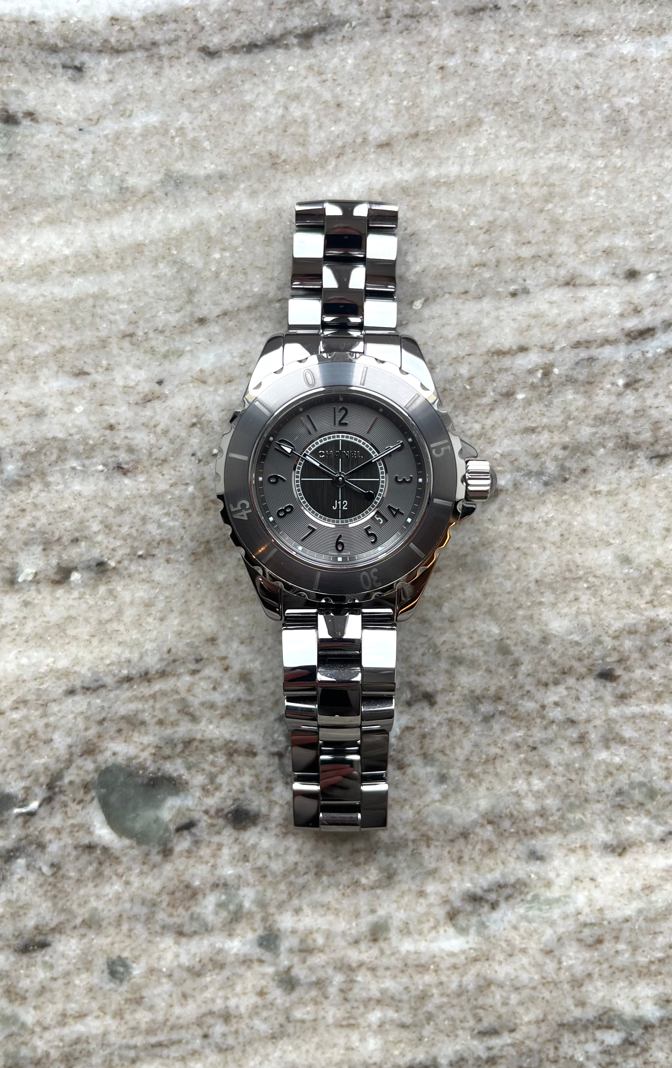 Chanel J12 33mm graue Keramikuhr mit silbernem Armband auf Marmor