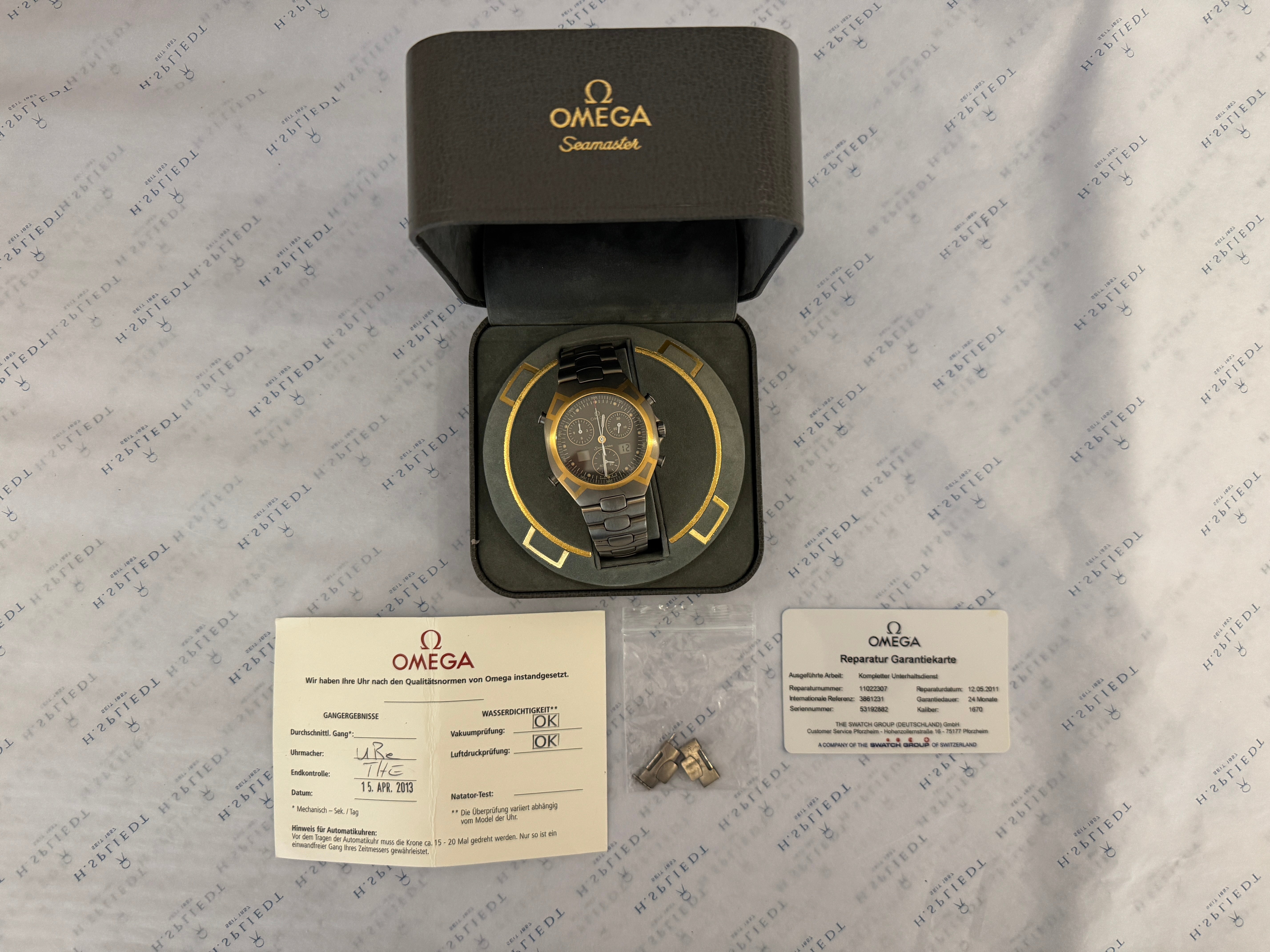 Omega Seamaster Polaris Grey mit goldenem Zifferblatt und bicolor Armband in einem geöffneten Karton