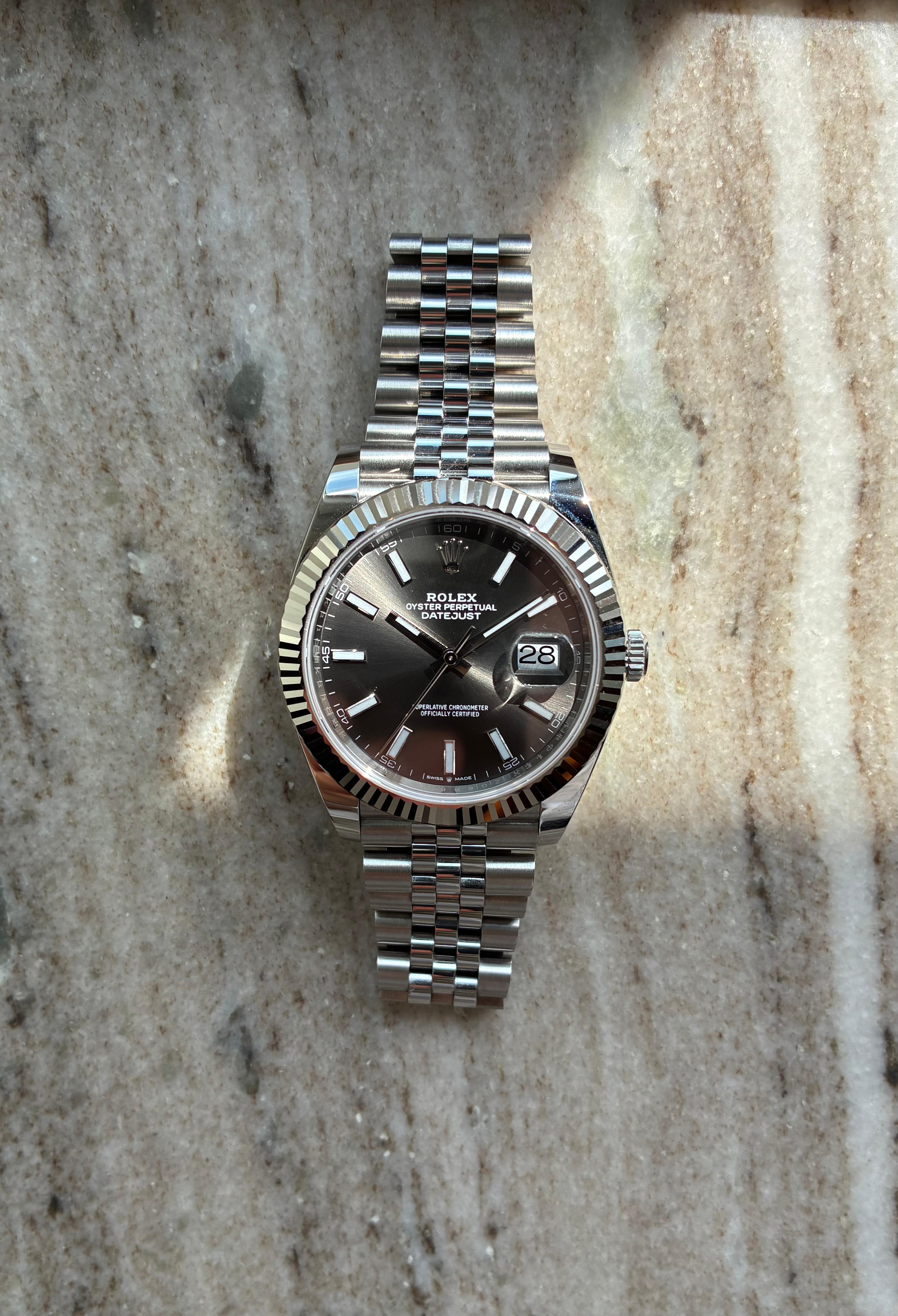 Rolex Datejust 41 mit grauem Zifferblatt in Frontansicht auf Marmor