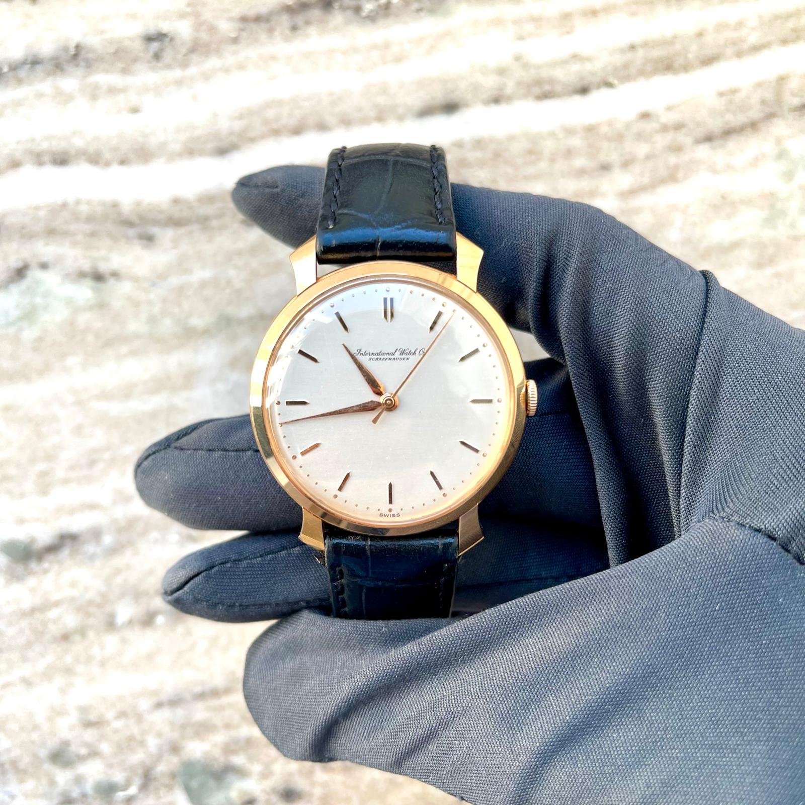 IWC Shark Fin Automatik Armbanduhr mit weissem Zifferblatt und schwarzem Lederarmband in der Hand