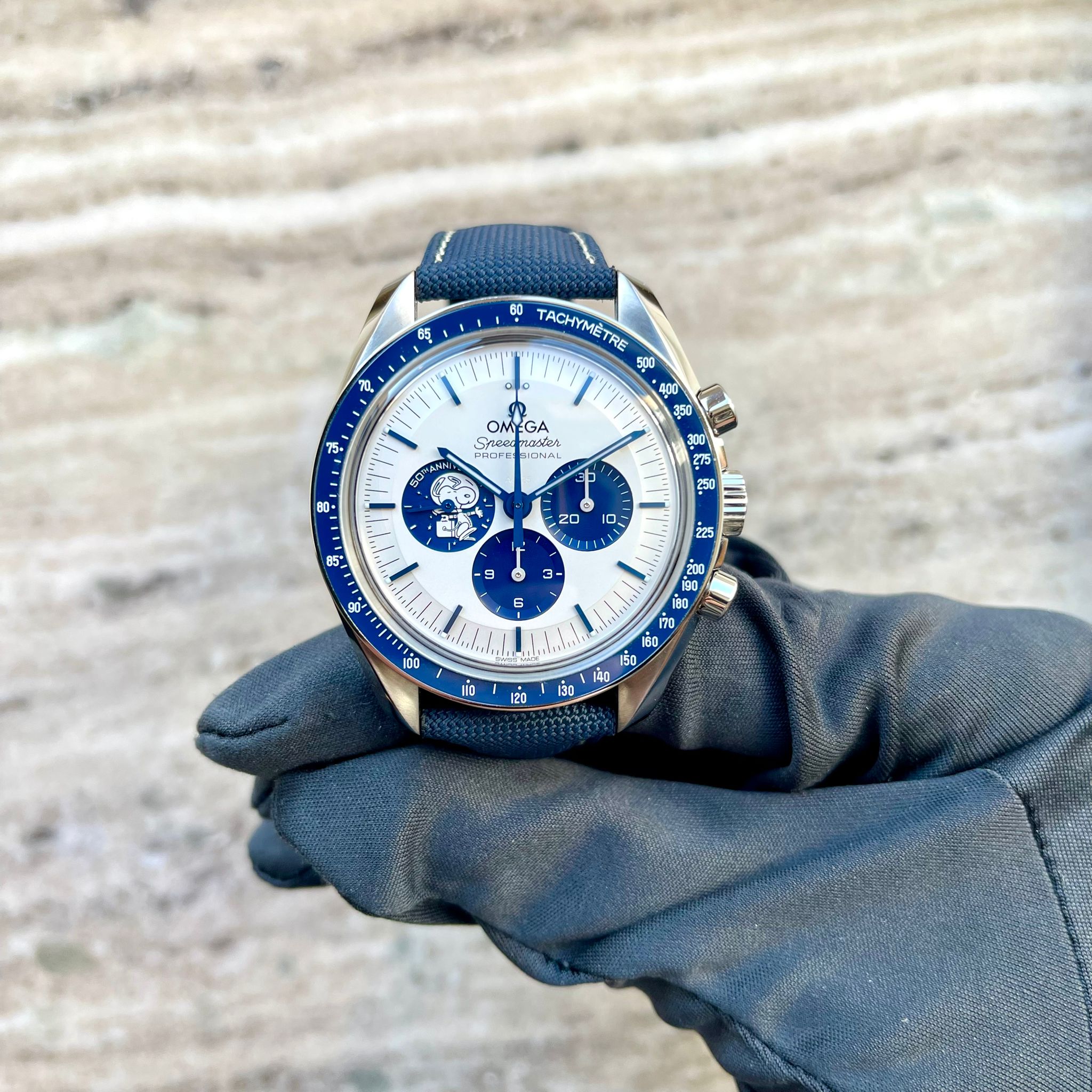 Omega Speedmaster "Silver Snoopy Award" 50th Anniversary (2022) im Detail von vorne mit blauen Akzenten und Snoopy-Grafik auf dem Zifferblatt