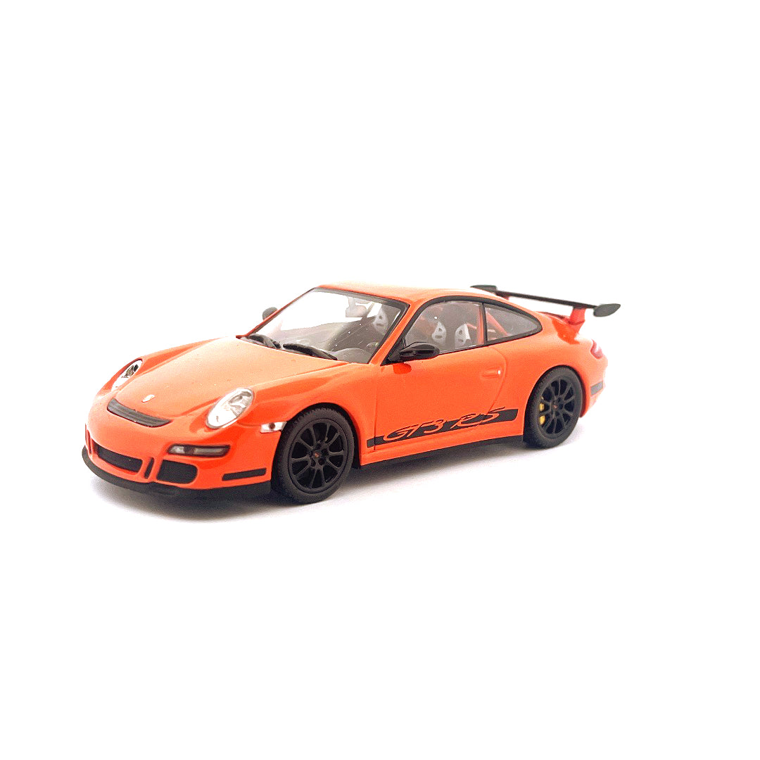 Ein orangefarbenes Porsche 911 GT3 RS Modellauto mit schwarzen Felgen und Flügel auf weißem Hintergrund