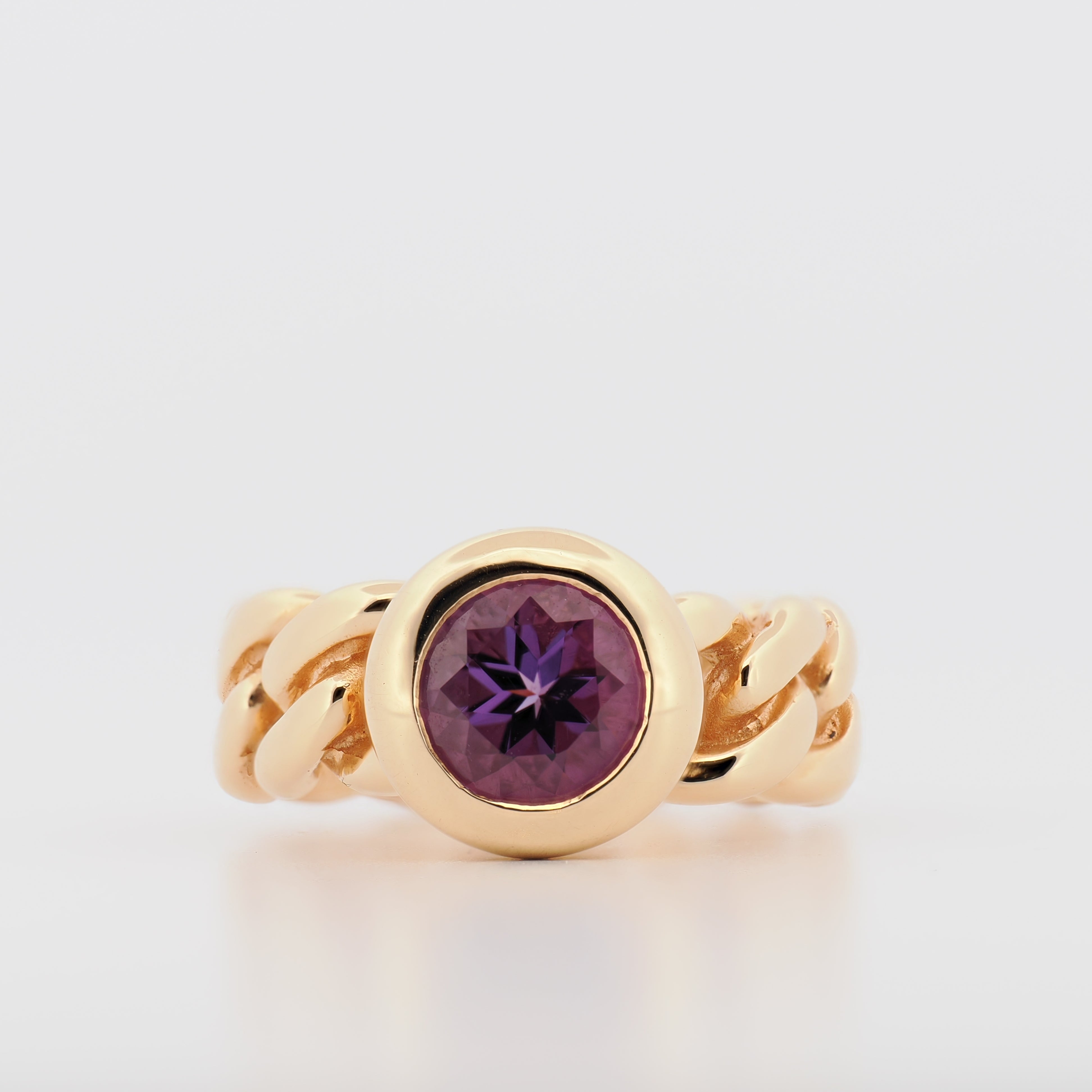 Bron 18K Roségoldring mit facettiertem Amethyst und geflochtenem Band vor weißem Hintergrund