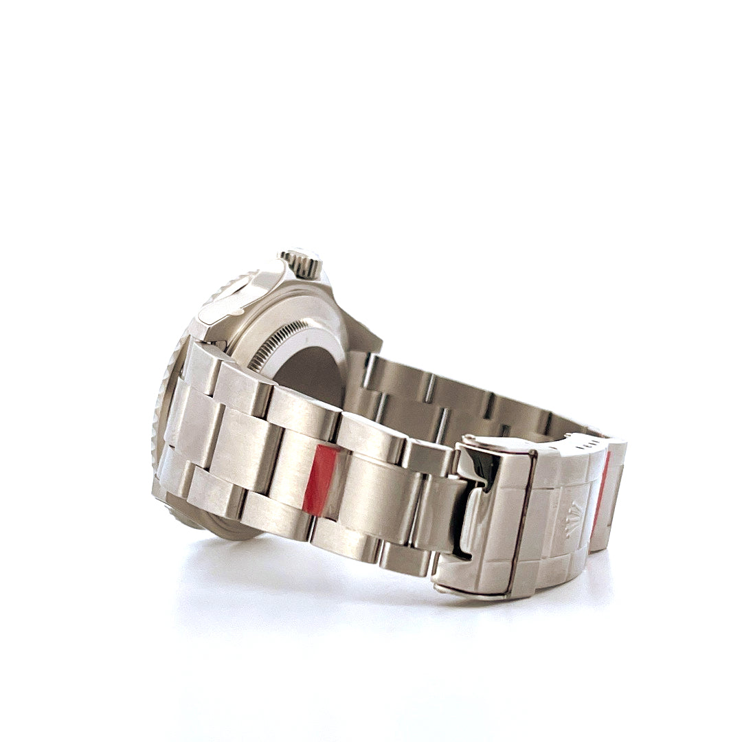 Rolex Kermit Submariner Date aus Stahl in Seitenansicht mit silbernem Armband und roten Akzenten
