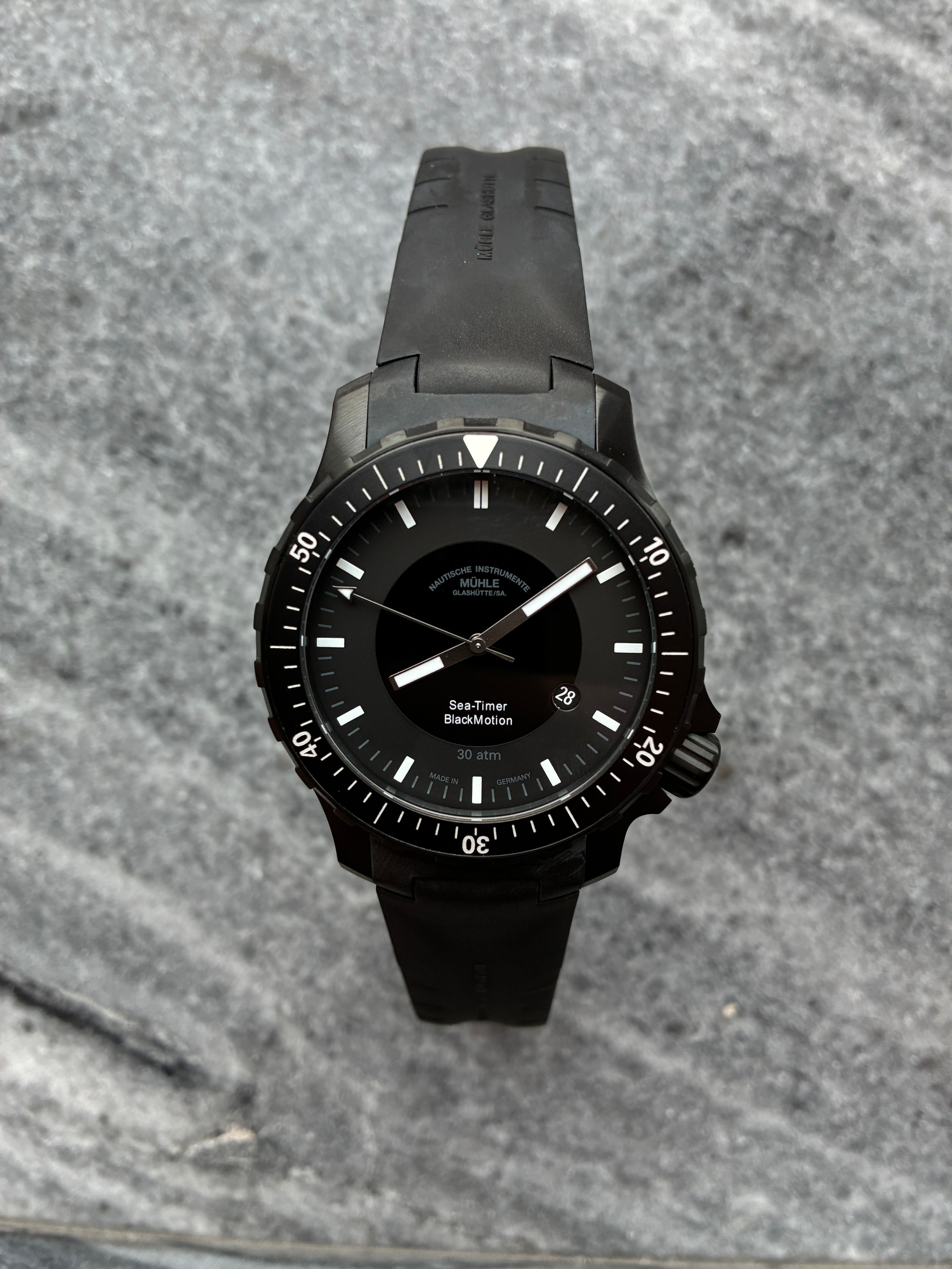 Mühle Glashütte Sea-timer Blackmotion Automatik Uhr mit schwarzem Zifferblatt und Kautschukband auf Steingrund