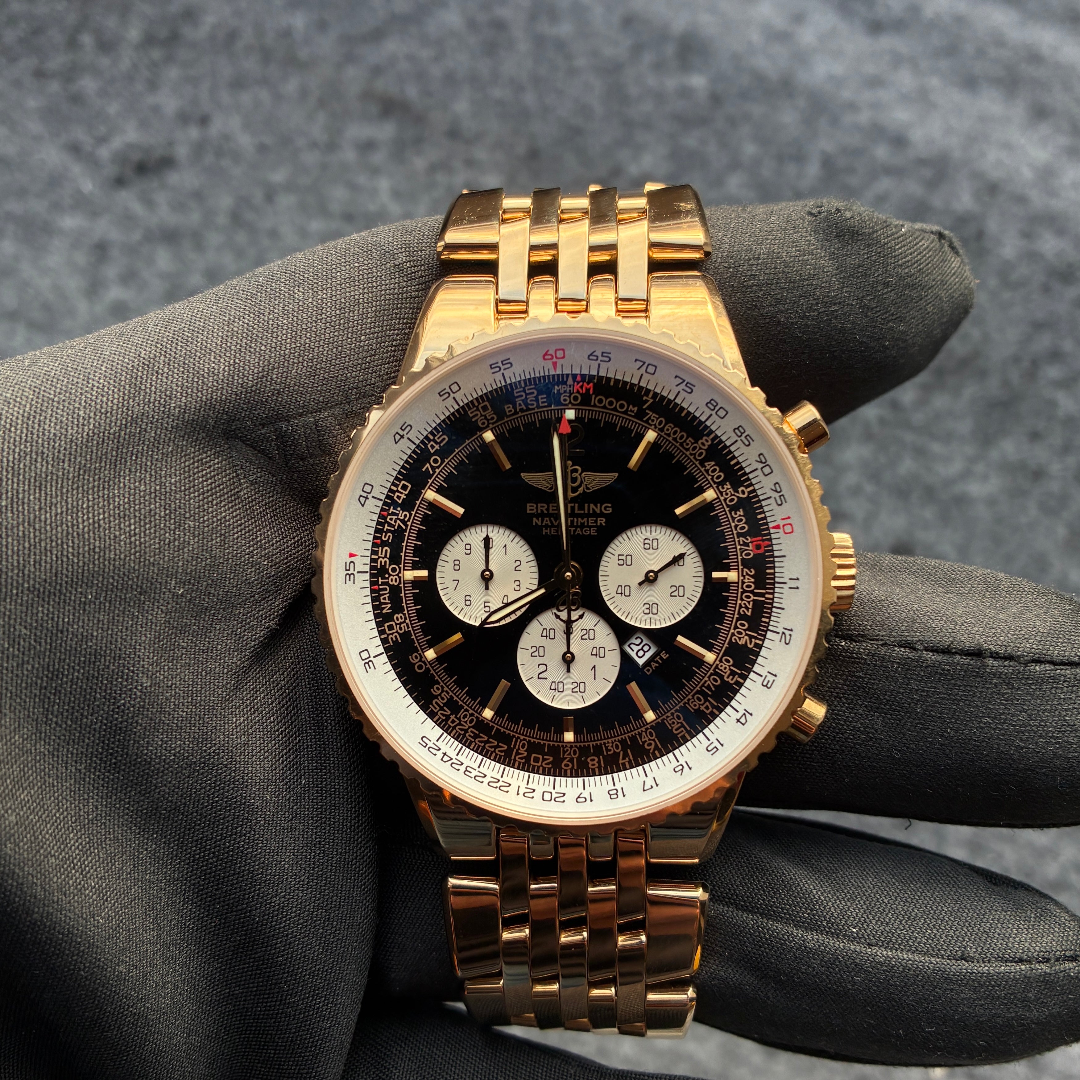 Eine Breitling Navitimer Heritage Uhr aus Gelbgold mit schwarzem Zifferblatt und goldenem Armband