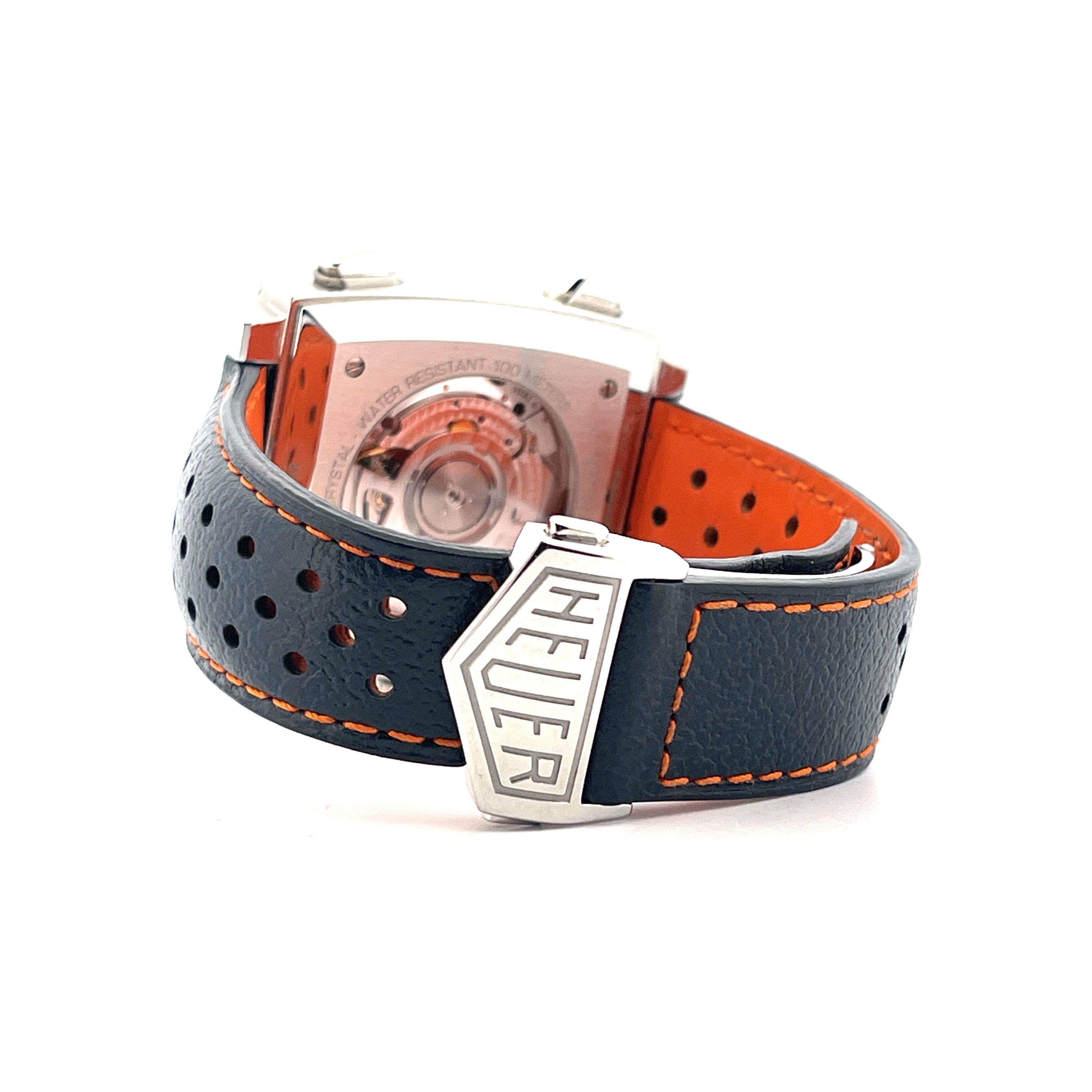 Tag Heuer Monaco Gulf mit schwarzem Lederarmband und orangefarbenem Futter vor weißem Hintergrund