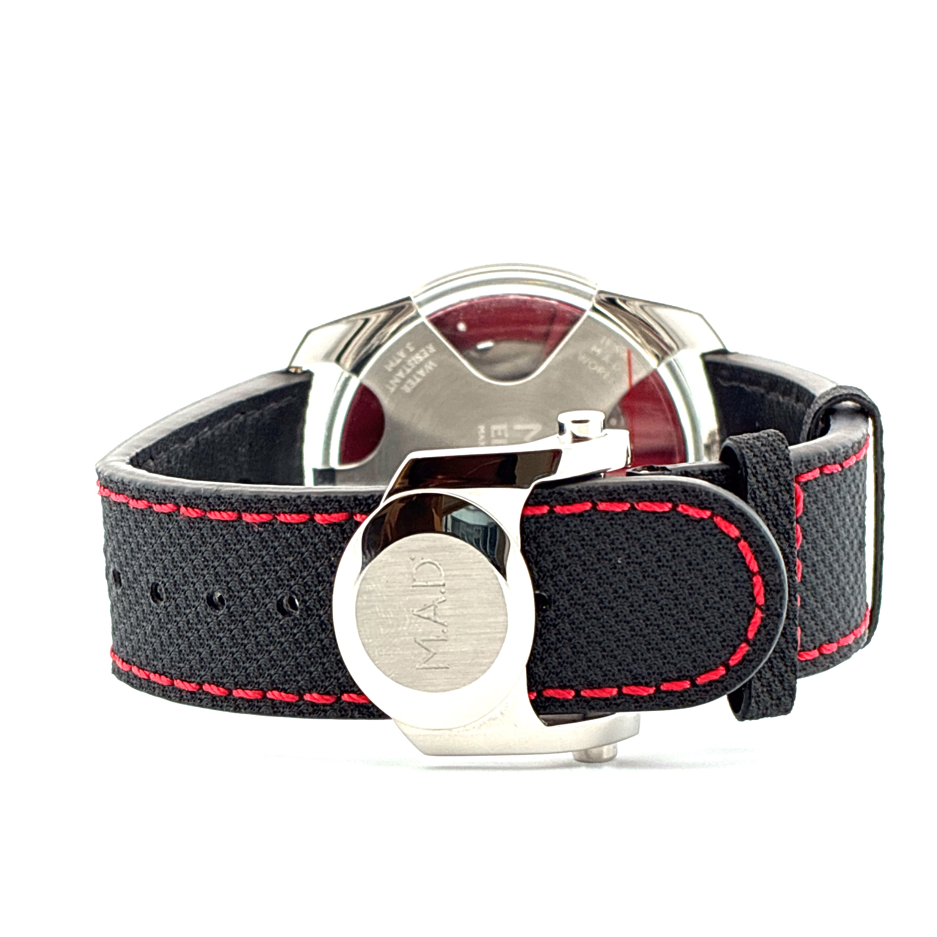 Rückansicht einer M.A.D. 1 Edition Armbanduhr mit schwarzem Textilarmband und roter Naht auf weißem Hintergrund